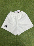Front view of white Canterbury kids' twill shorts with elastic waistband on grass