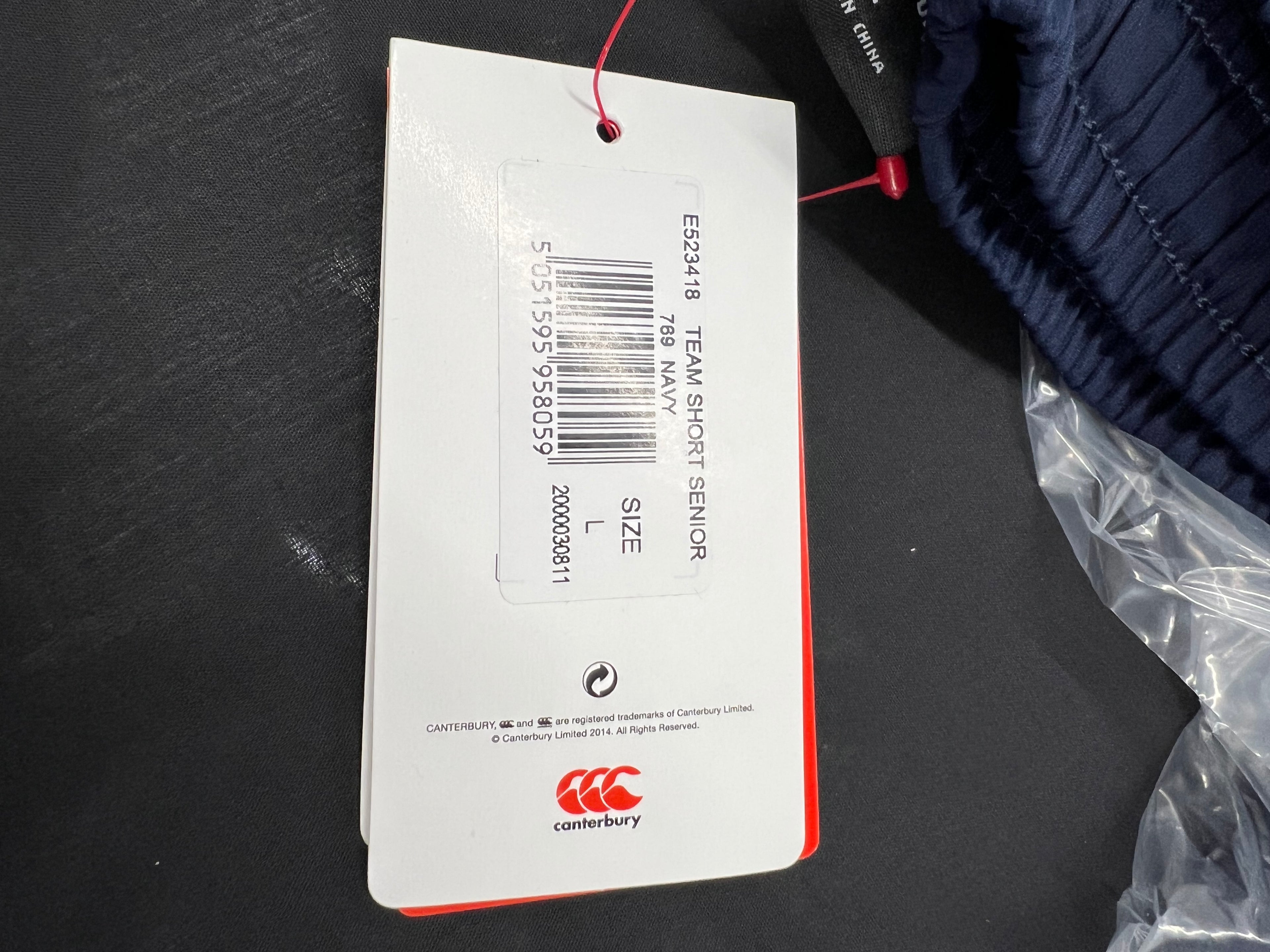 Close-up of product tag showing size L and product details on Canterbury team shorts
