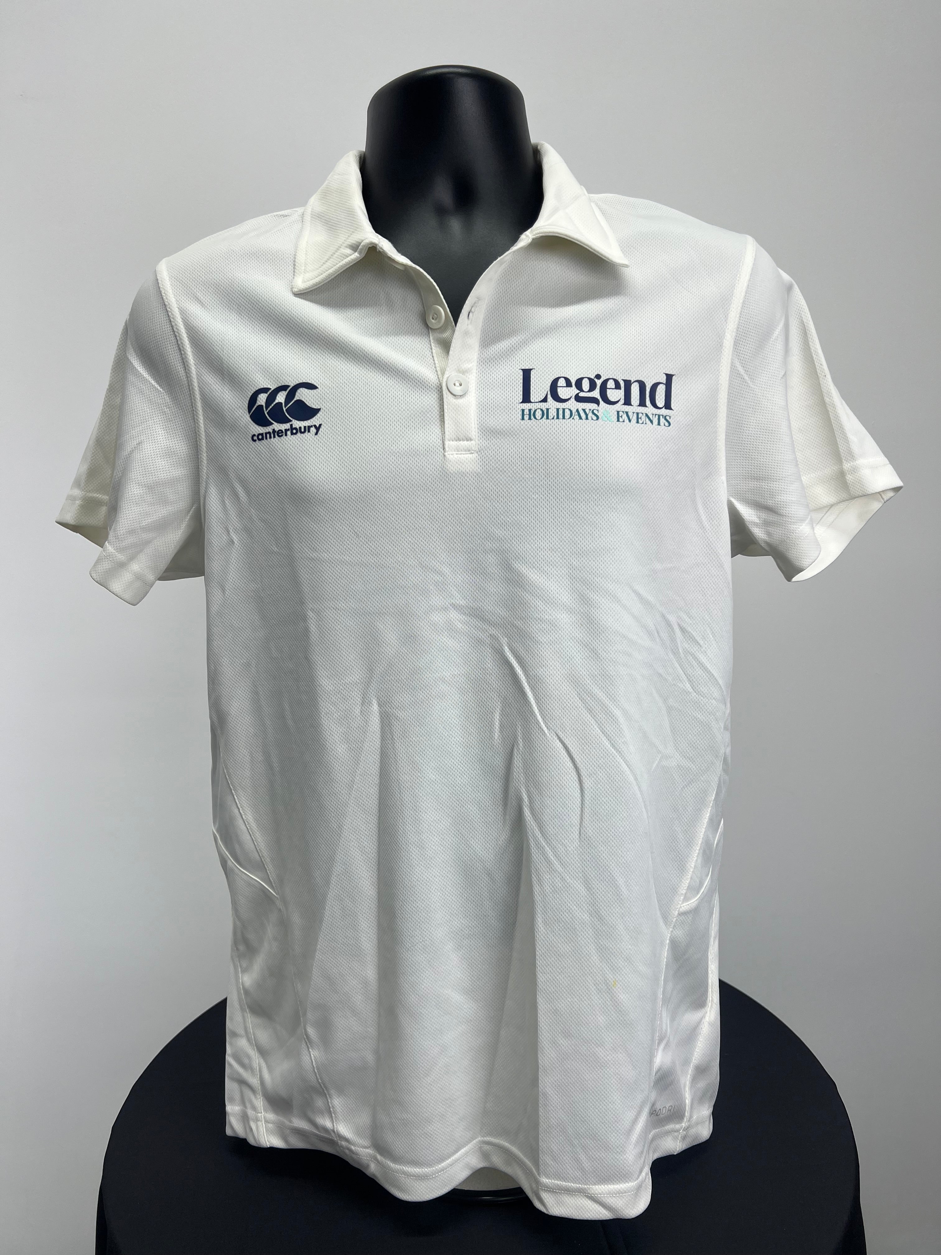Front view of Men’s Canterbury cream cricket shirt with Canterbury logo and Legend Holidays & Events print
