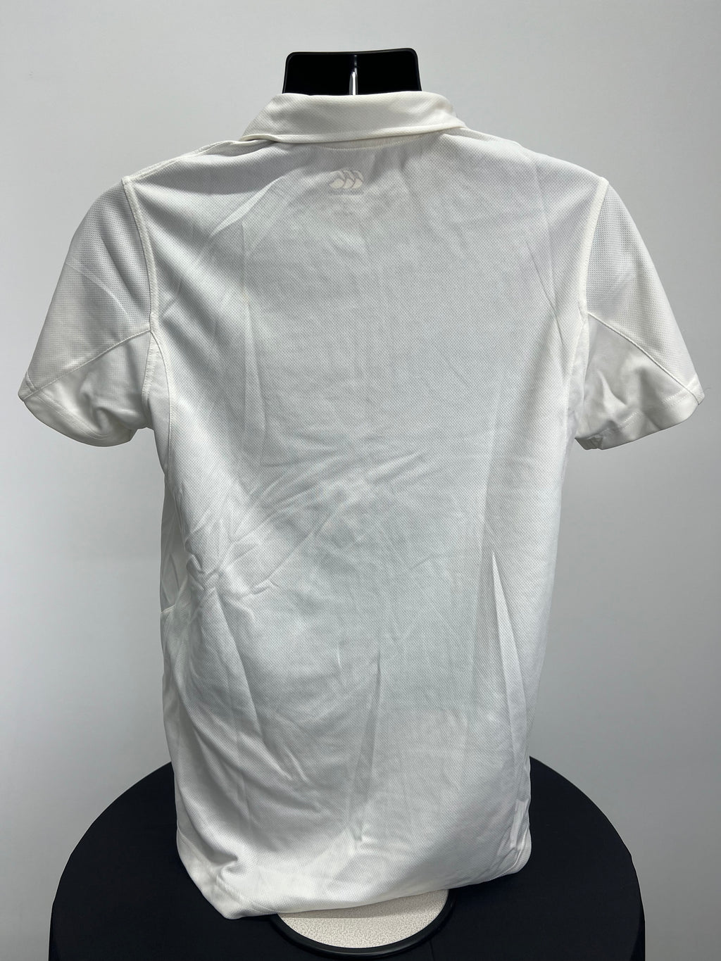 Back view of Men’s Canterbury cream cricket shirt showing plain design with subtle Canterbury logo on collar