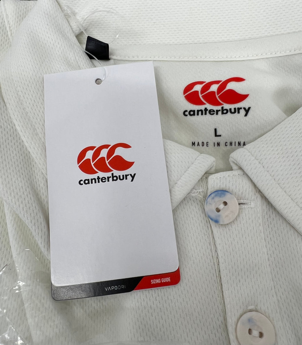Close-up of Canterbury branded tag and button details on Men’s cream cricket shirt, size Large