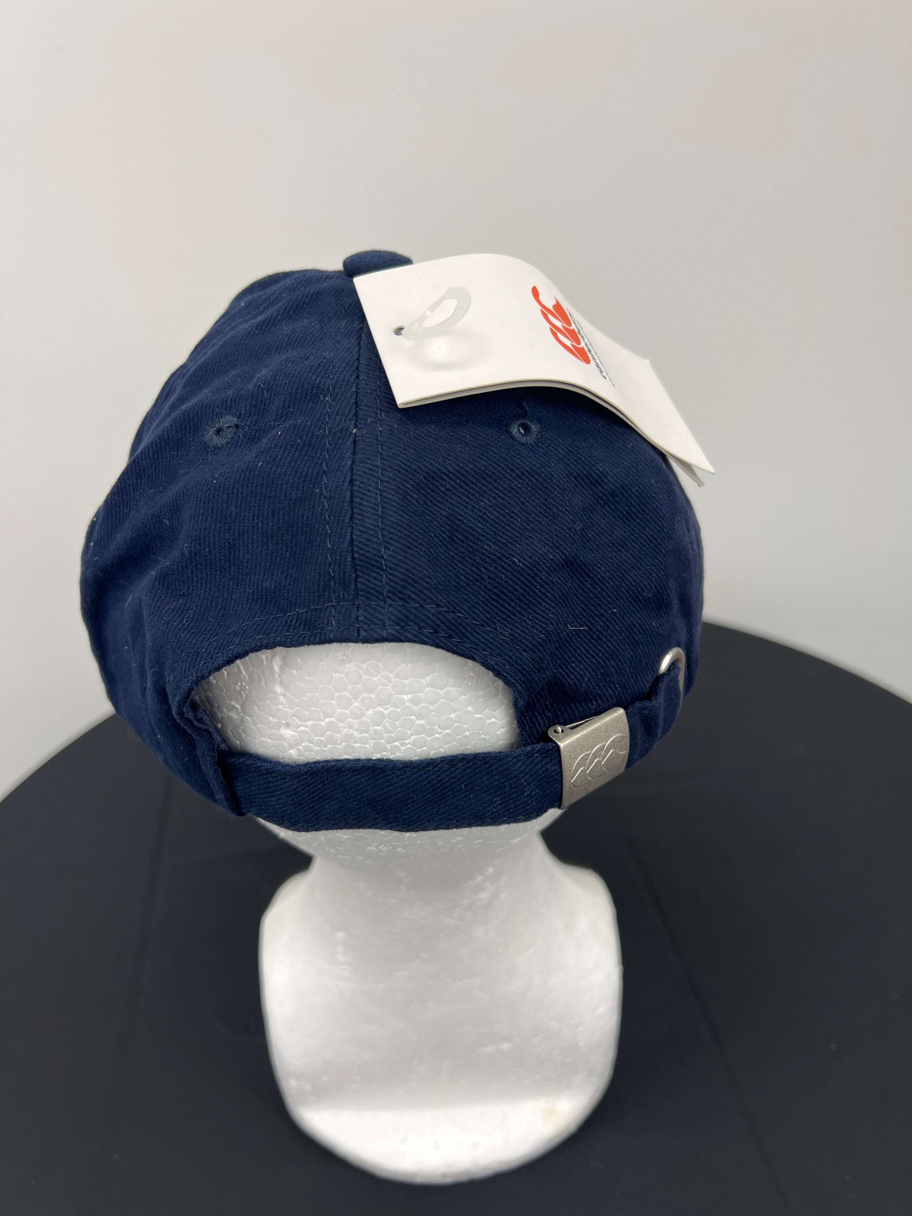 Rear view of navy Canterbury cap with adjustable strap and metal clasp