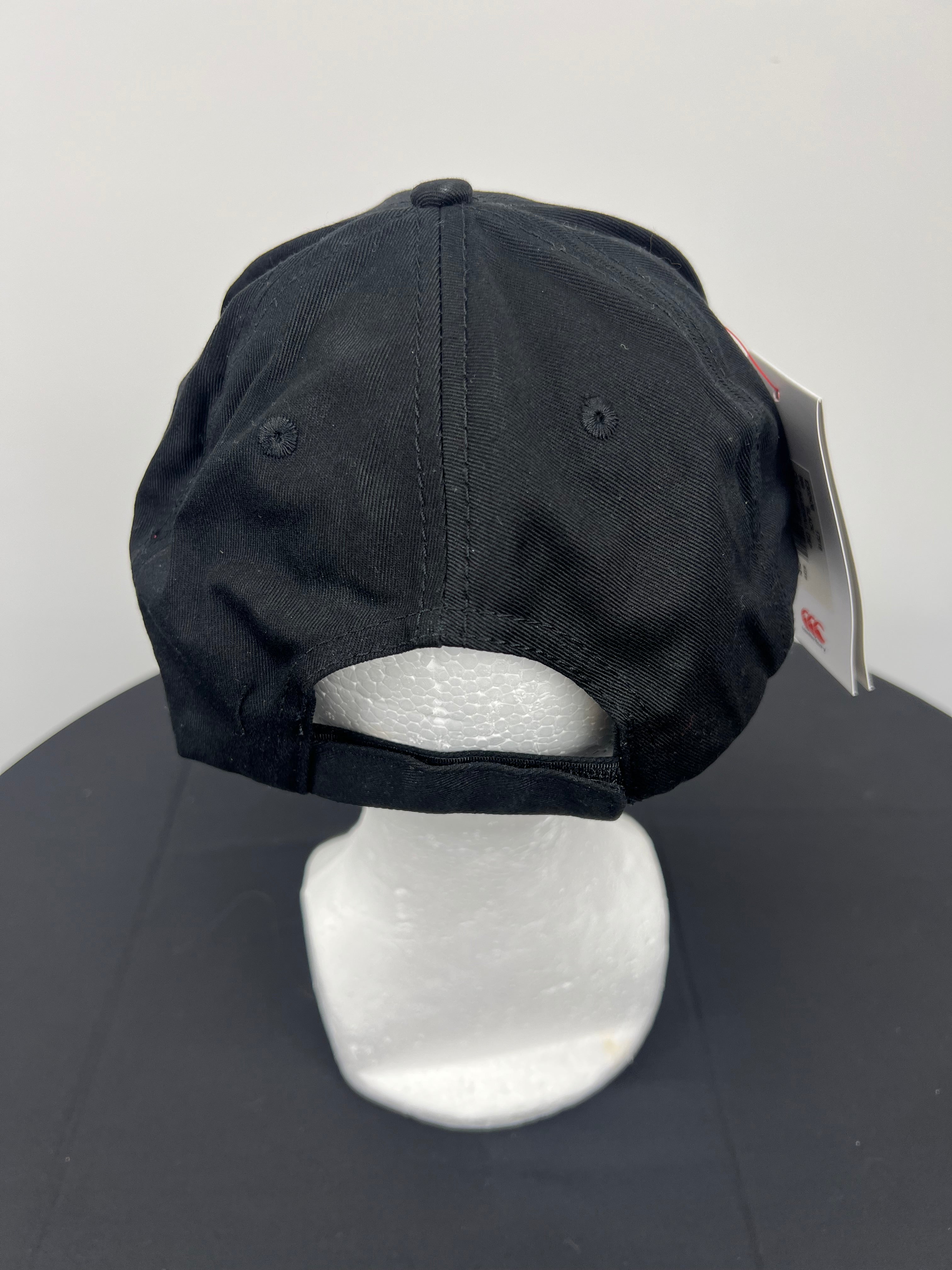 Rear view of black cap with adjustable strap on white mannequin