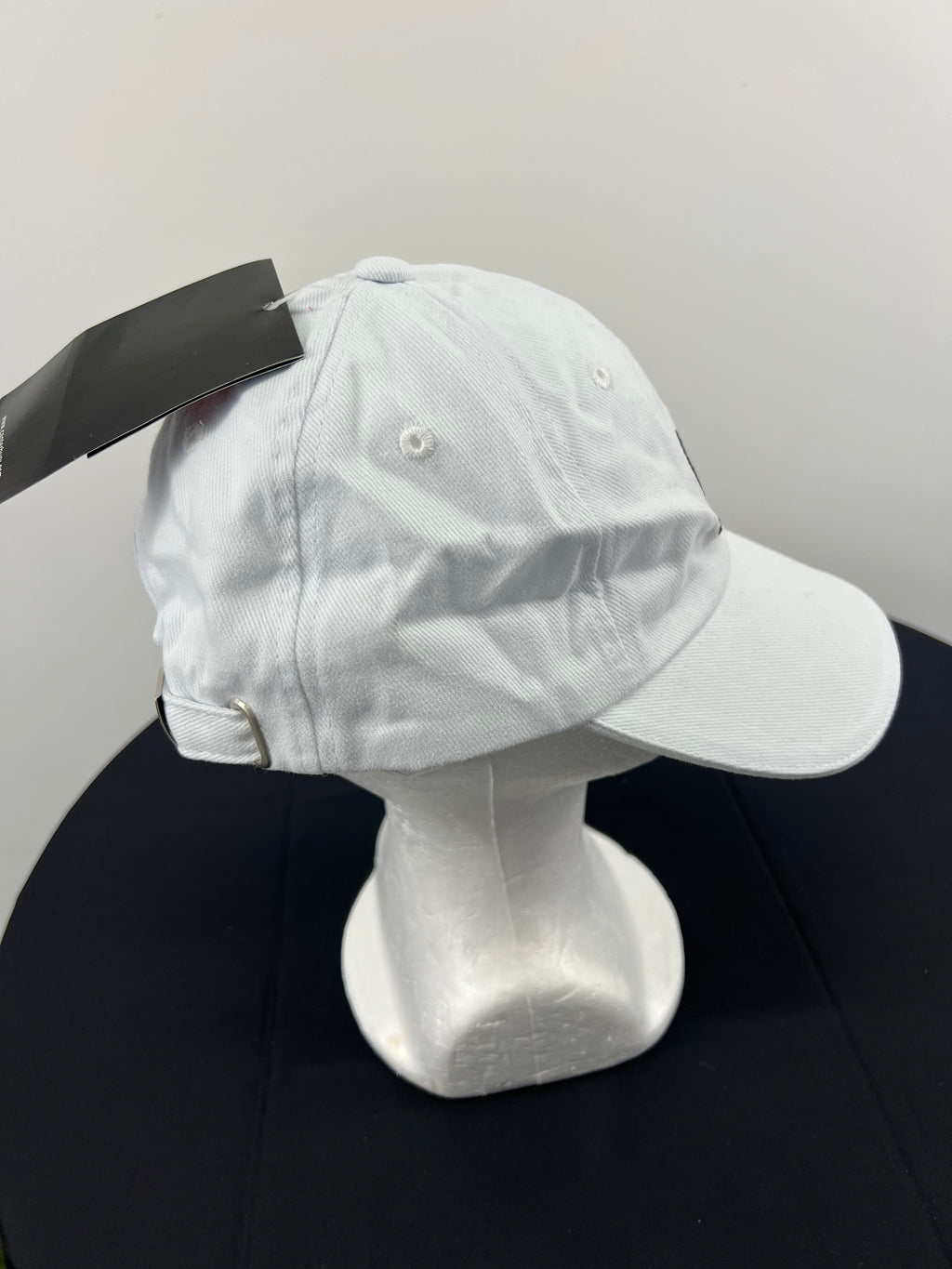 Right side view of white Canterbury cap showing curved brim and ventilation eyelets