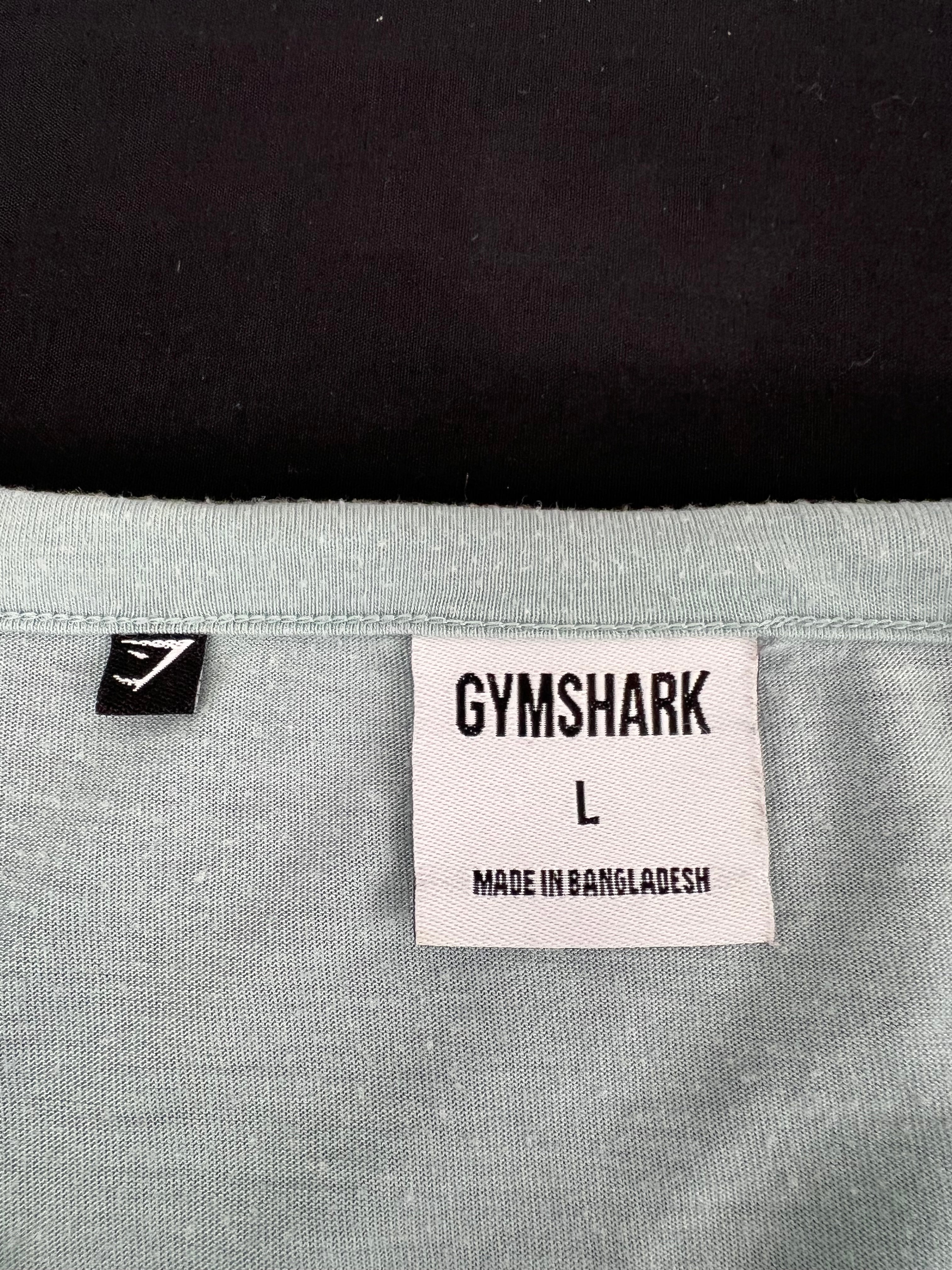 Close-up of size and brand labels inside the neckline of Gymshark light green t-shirt