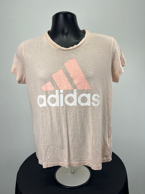 Front view of Adidas pink t-shirt with coral logo and white lettering on black mannequin