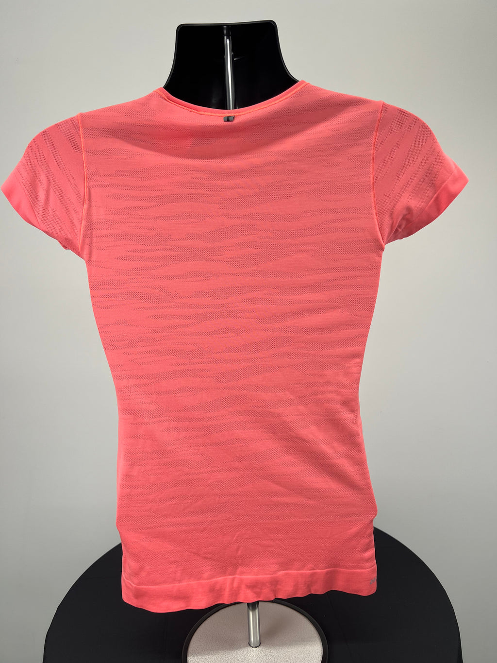 Back view of bright orange Nike Dri-FIT V-neck T-shirt showing mesh pattern