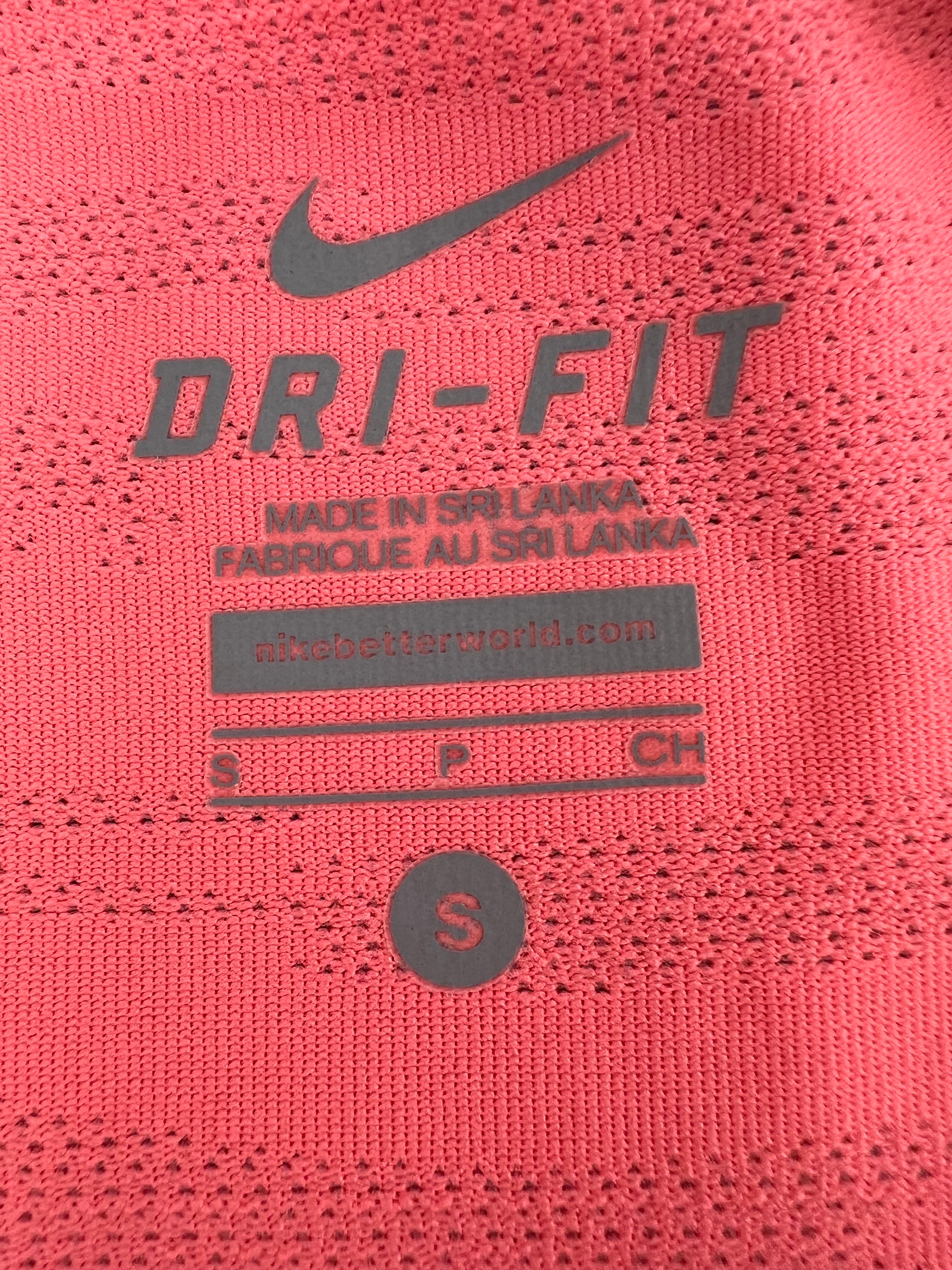 Close-up of Nike Dri-FIT logo and size label printed inside the orange T-shirt