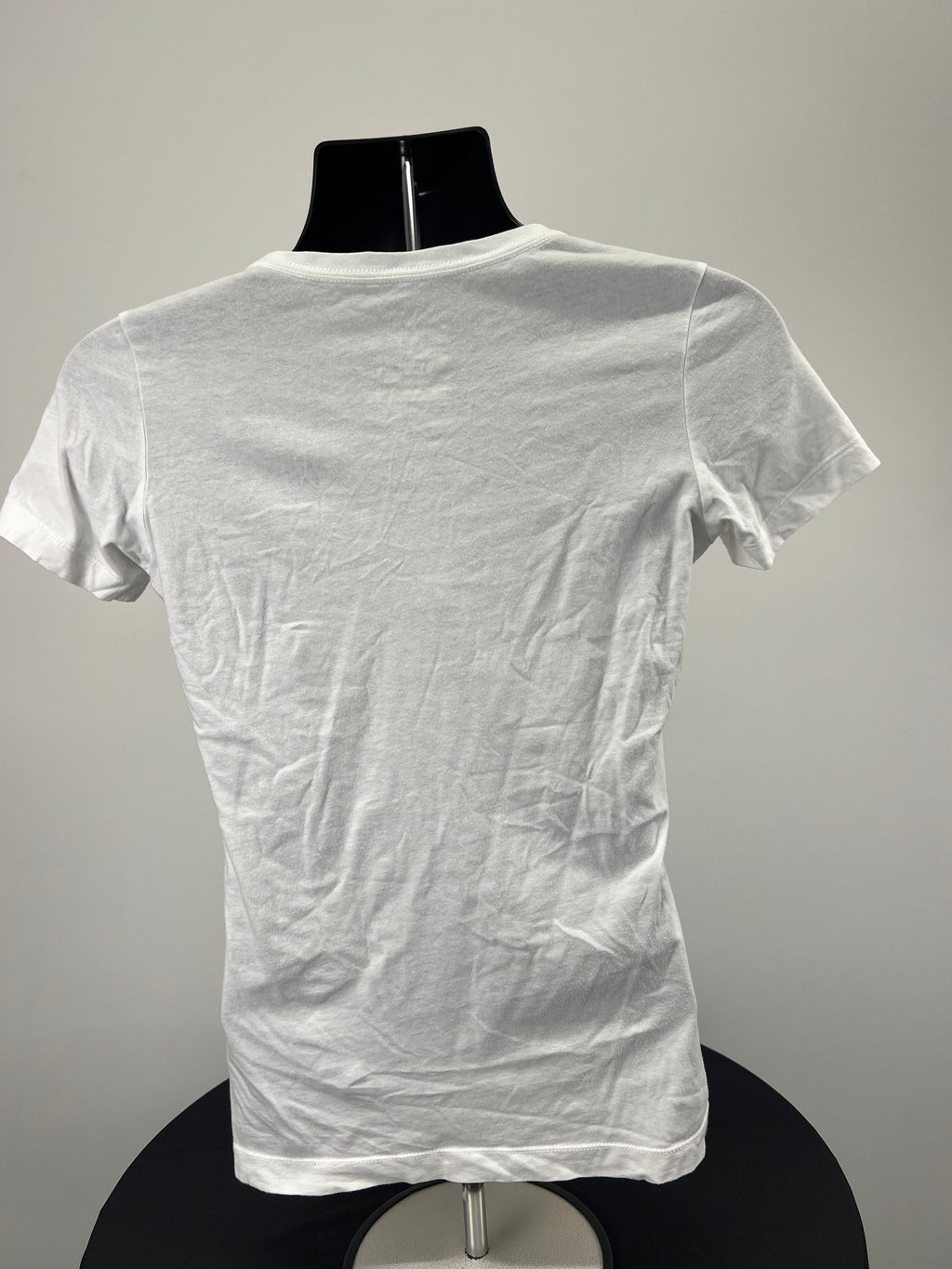 Back view of Nike slim fit white V neck t-shirt on mannequin showing plain design