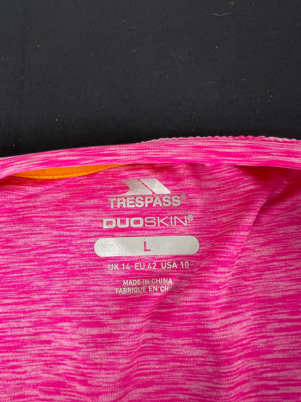 Close-up of size label inside Trespass Duoskin pink T-shirt showing size L and brand logo