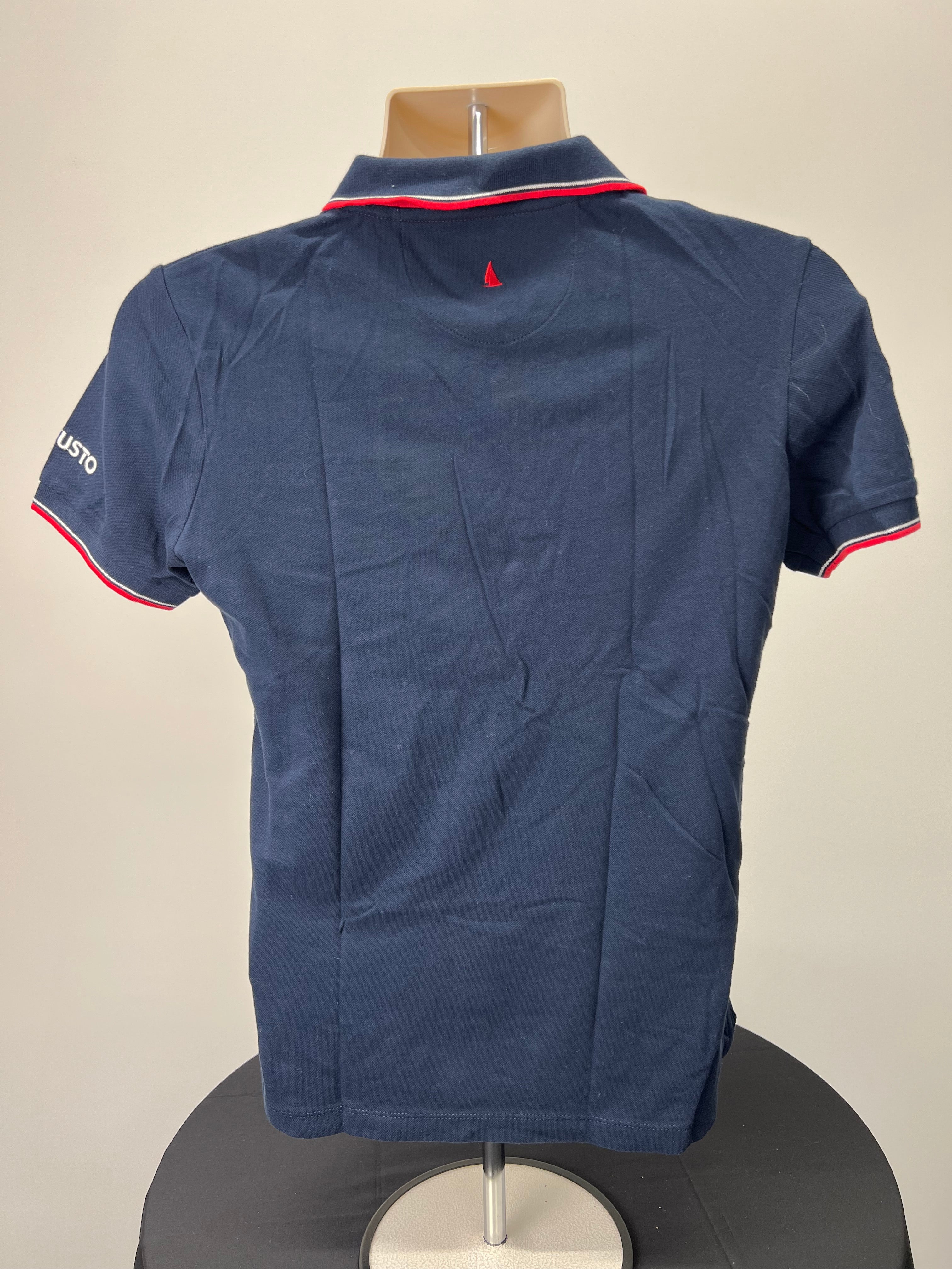 Back view of navy polo shirt showing plain design with small red sailboat embroidery on collar