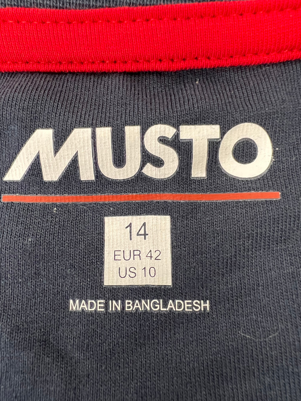 Label inside navy t-shirt showing Musto branding and size information with Made in Bangladesh tag