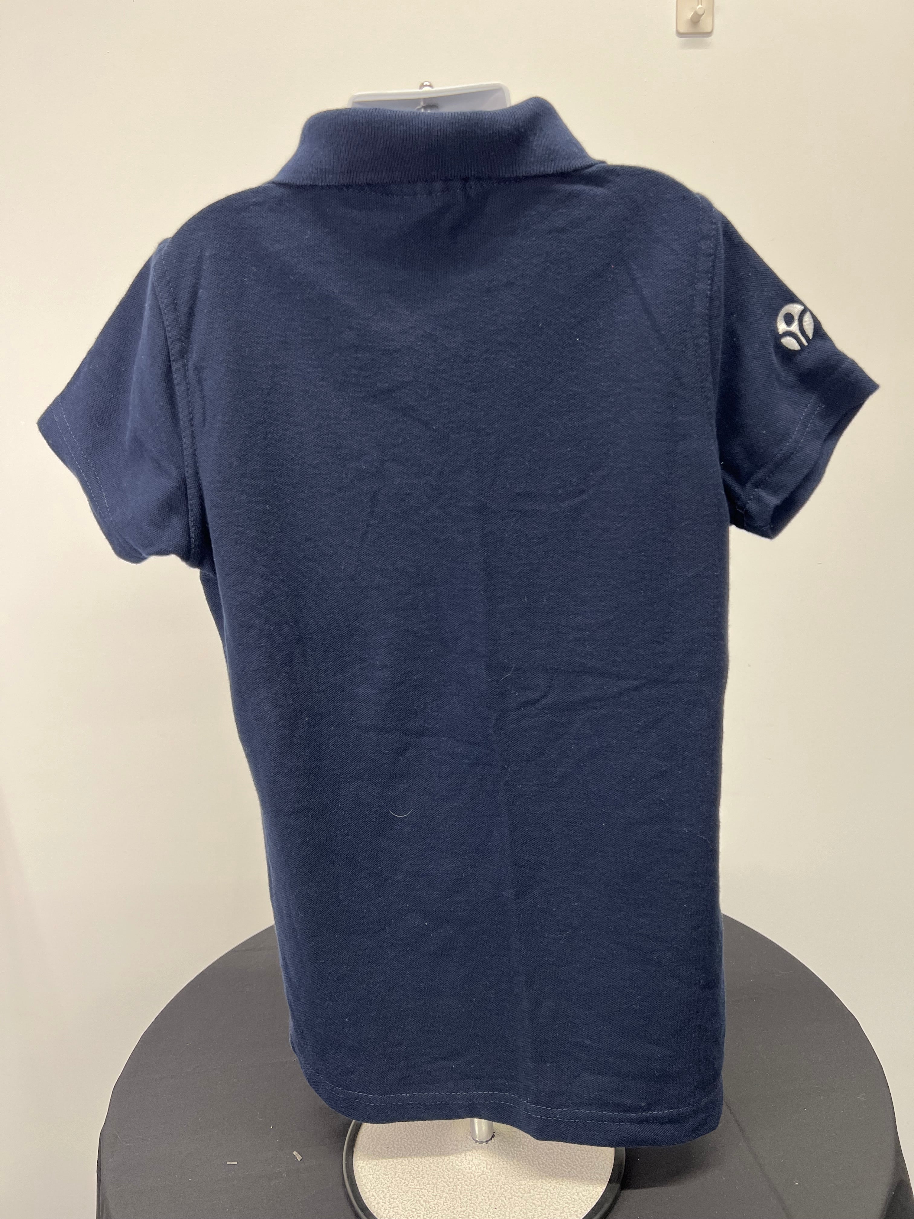 Back view of navy polo shirt showing plain back and short sleeves
