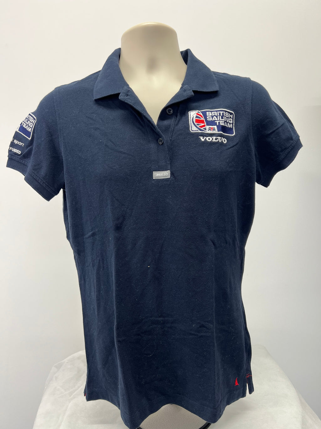 Front view of navy Musto British Sailing Team polo shirt with collar and embroidered chest logos