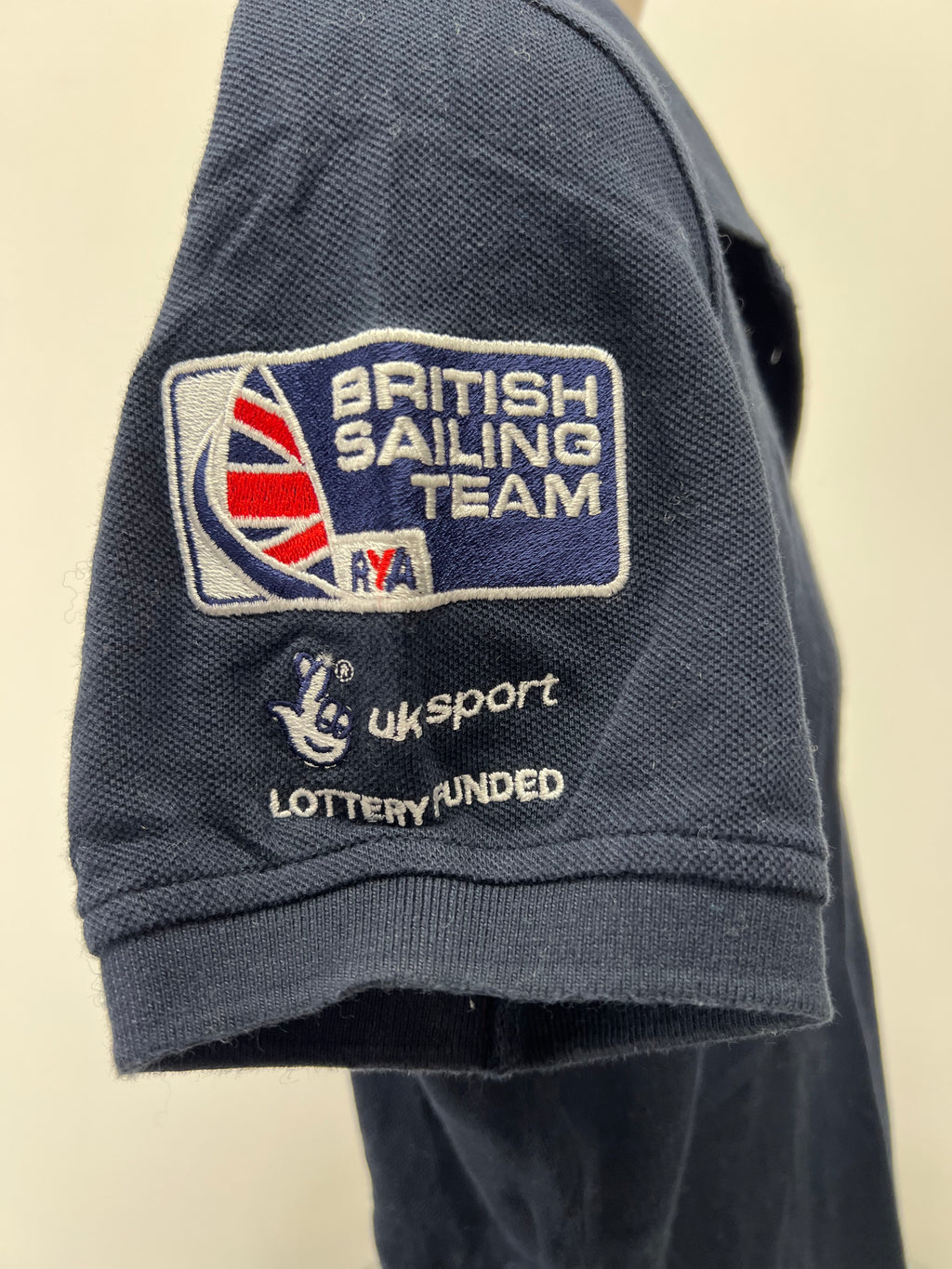 Close-up of sleeve embroidery with British Sailing Team badge, UK Sport logo, and lottery funded text