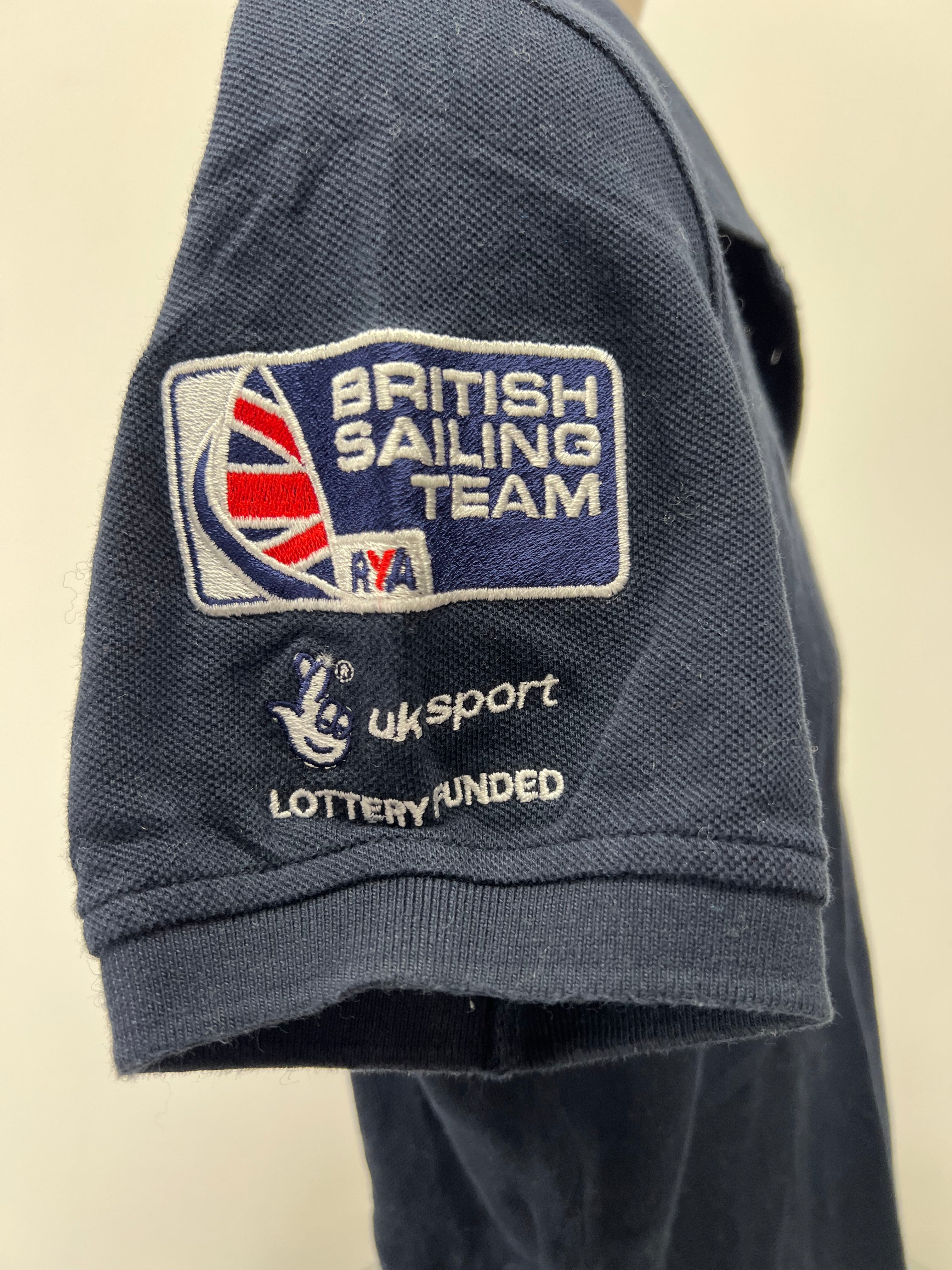 Close-up of sleeve embroidery with British Sailing Team badge, UK Sport logo, and lottery funded text