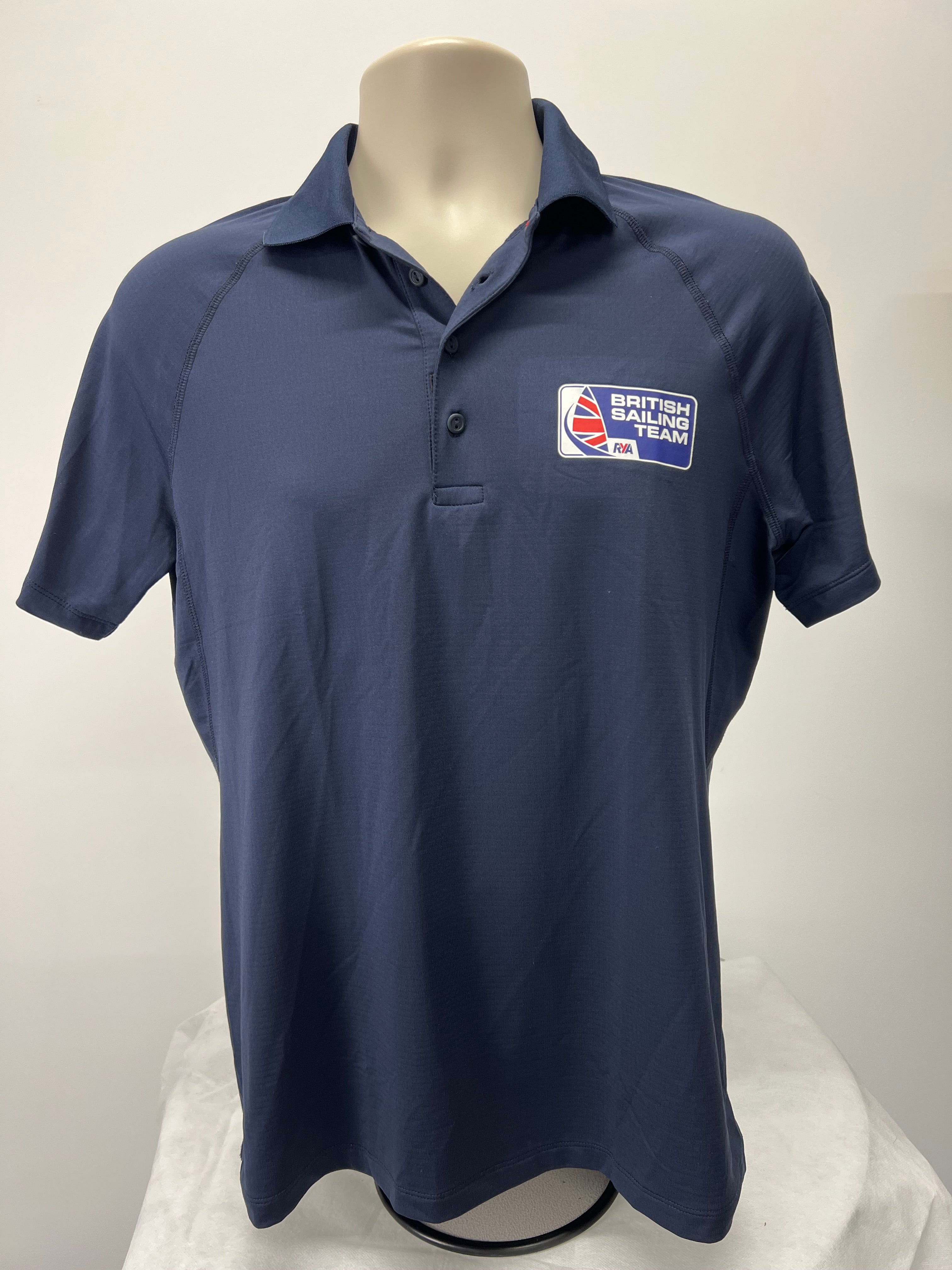 Navy blue Musto British Sailing Team polo shirt front view on mannequin