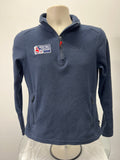 Front view of navy blue Musto British Youth Sailing half-zip fleece sweatshirt with zippered pockets and branded logo patches
