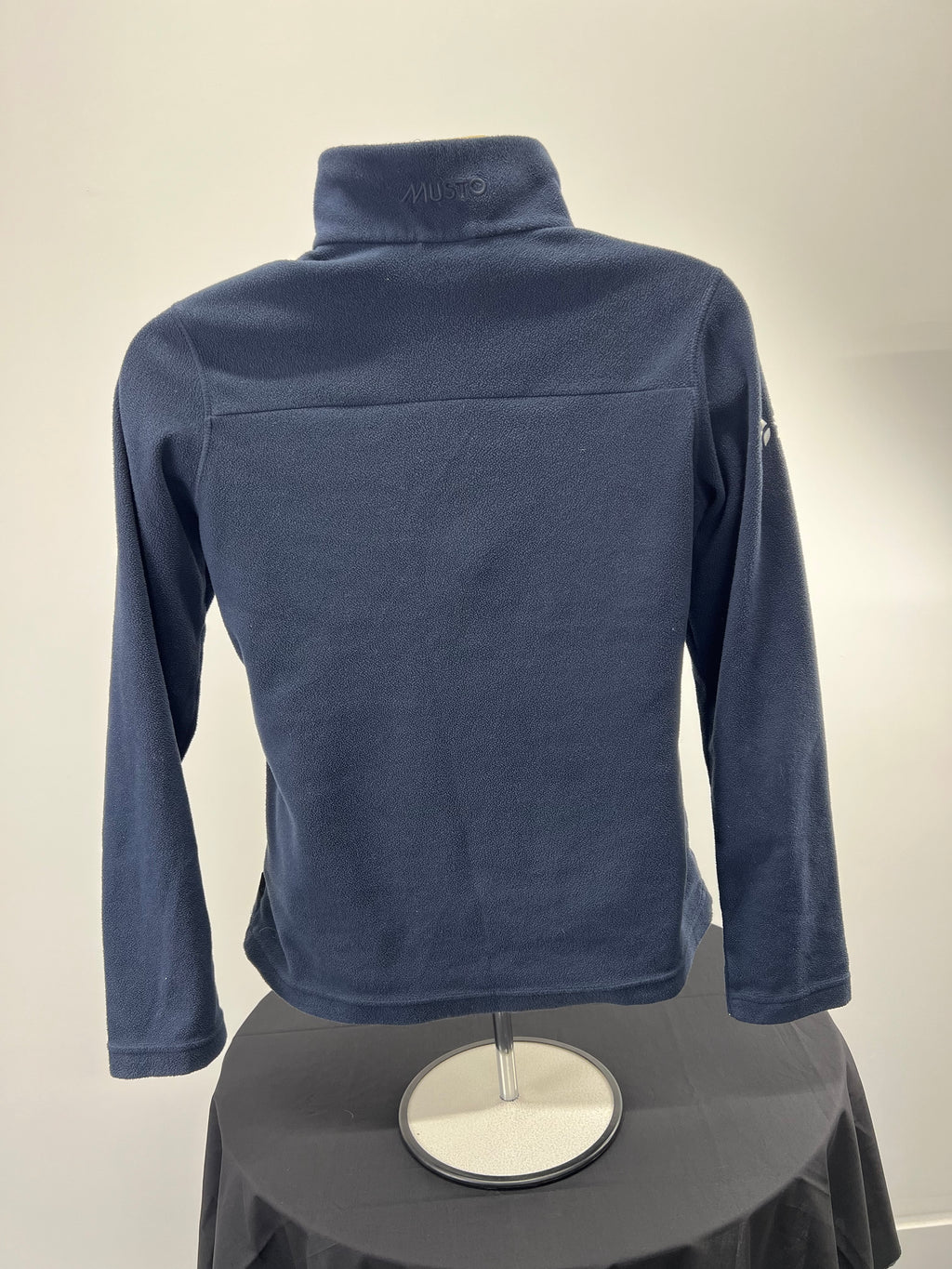 Back view of navy Musto fleece with plain fleece fabric and high collar