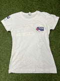 Front view of a white women's British Sailing Team t-shirt with small logo on chest and sleeve branding on grass background