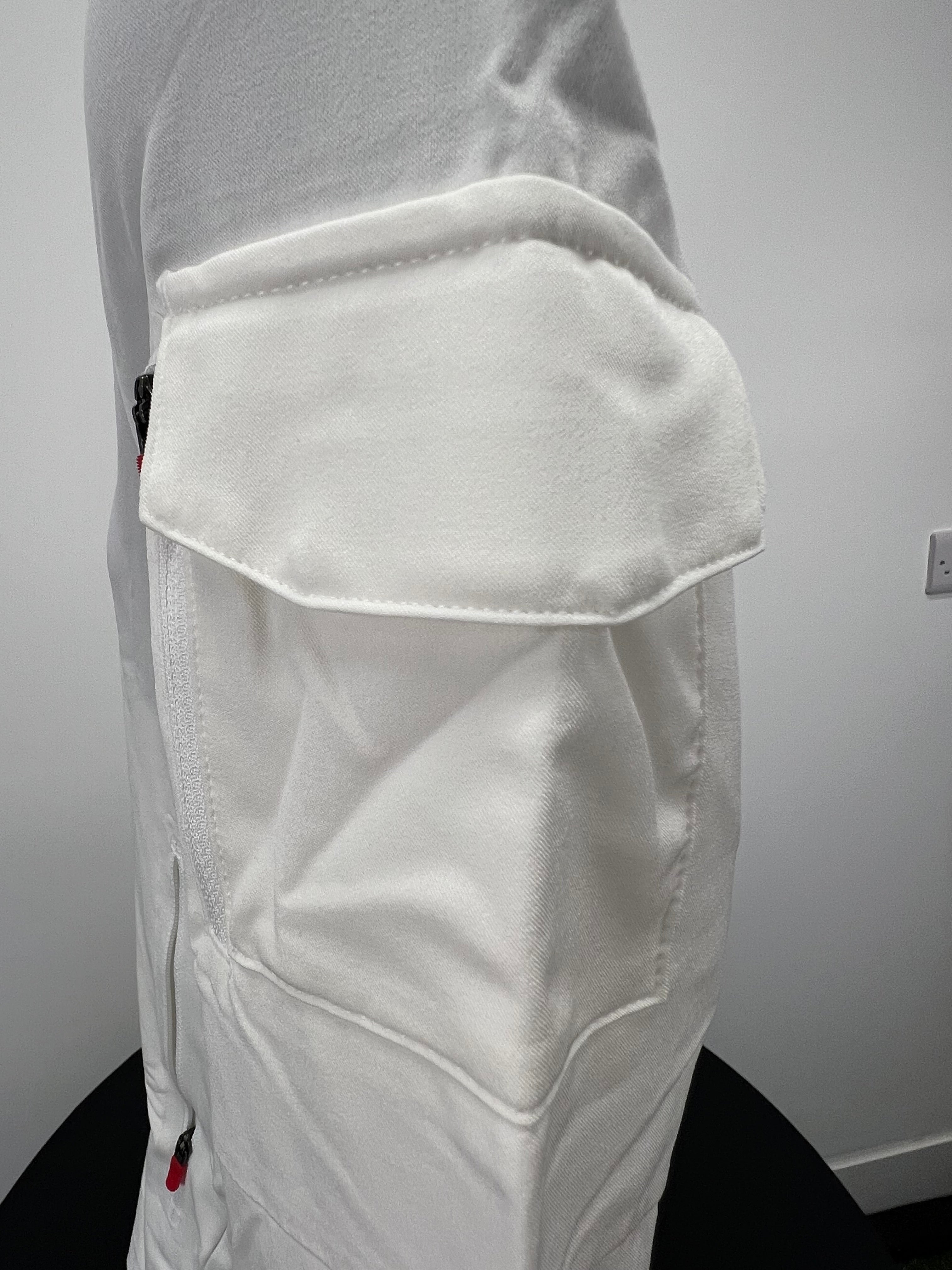 Close-up of zippered flap pocket on sleeve of cream Nike zip-up jacket