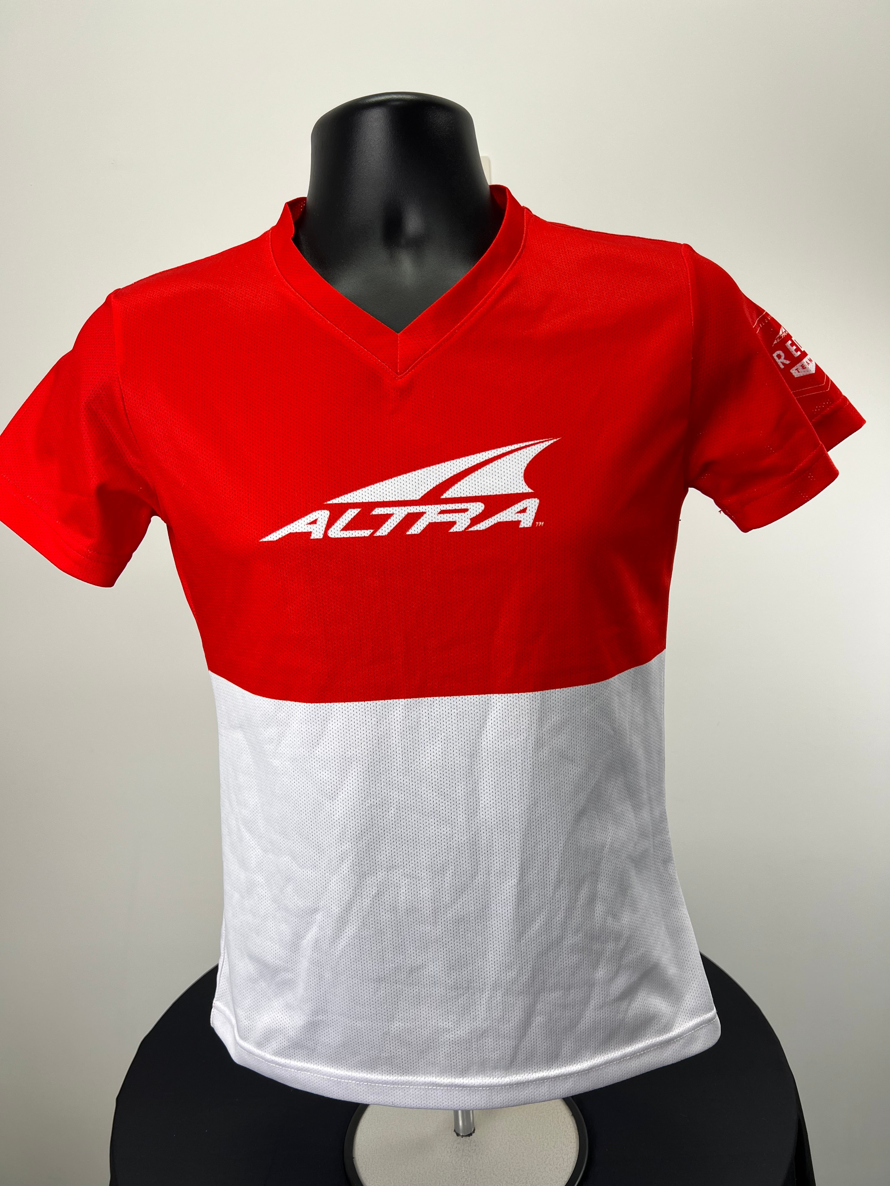 Front view of Altra women's V-neck sport t-shirt in red and white mesh fabric on black mannequin