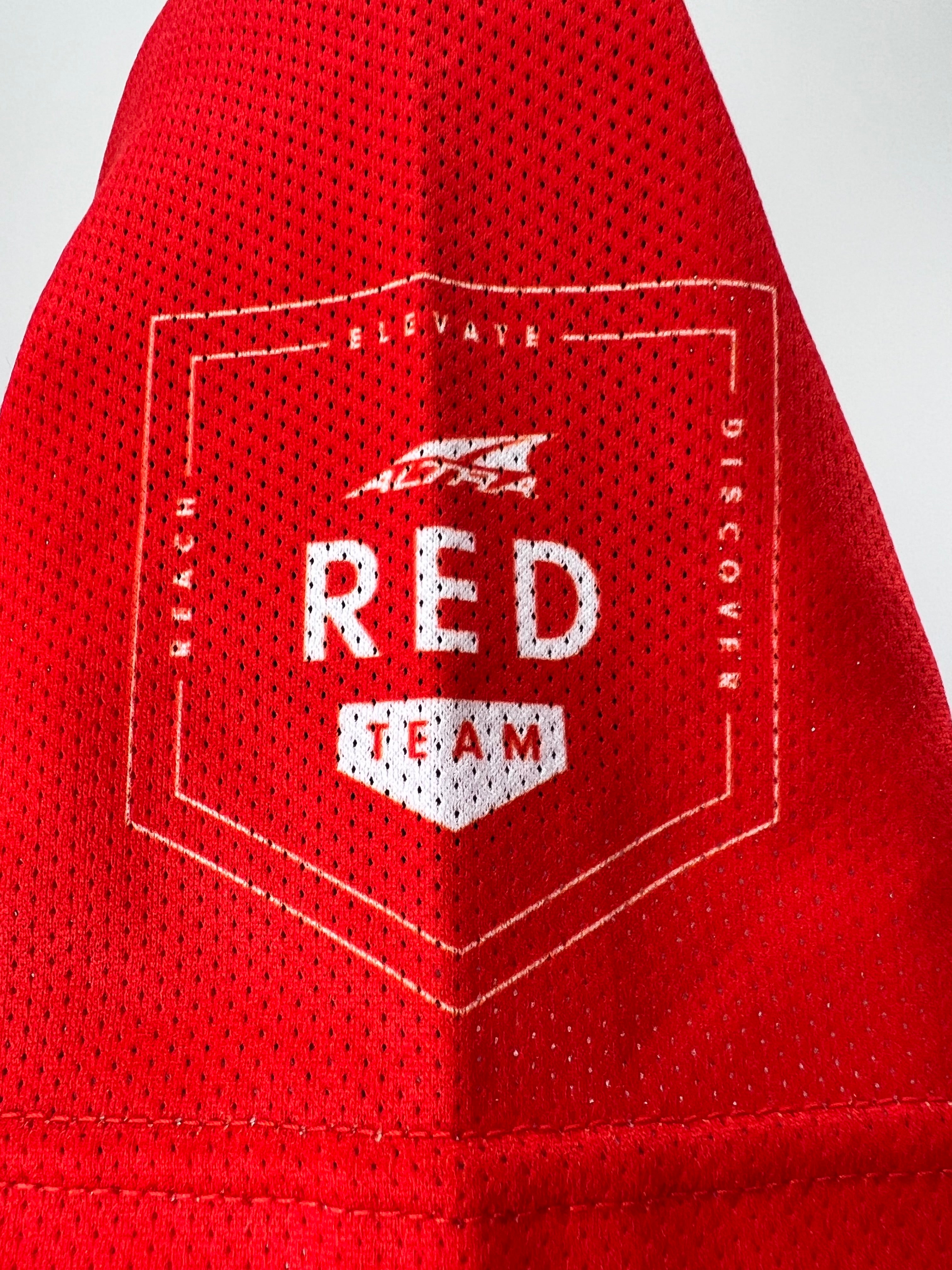 Close-up of red mesh fabric sleeve detail with 'Red Team' emblem printed in white