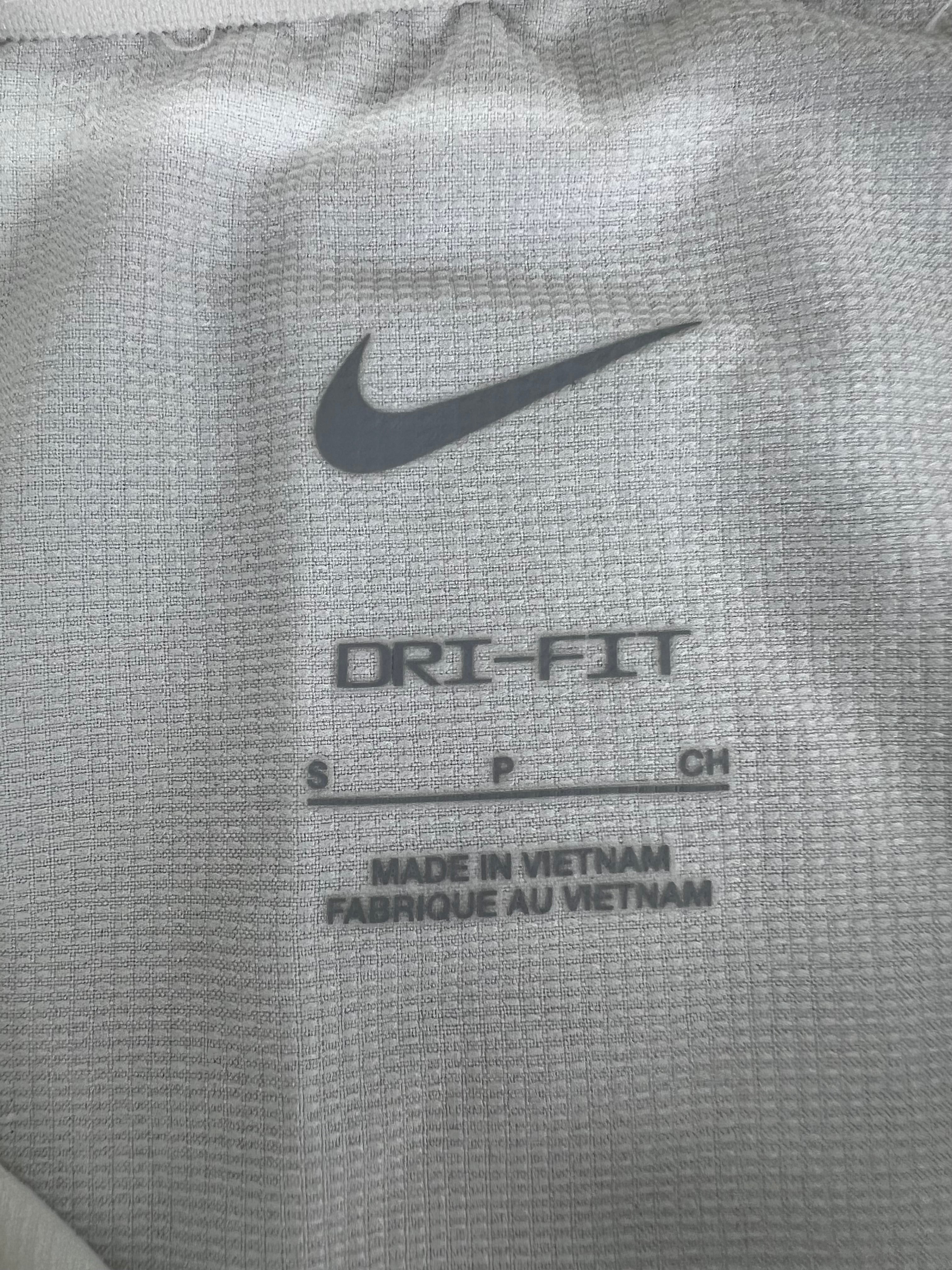 Close-up of the inner neck label of the jacket showing Nike logo, Dri-FIT branding, size small, and 'Made in Vietnam' text.