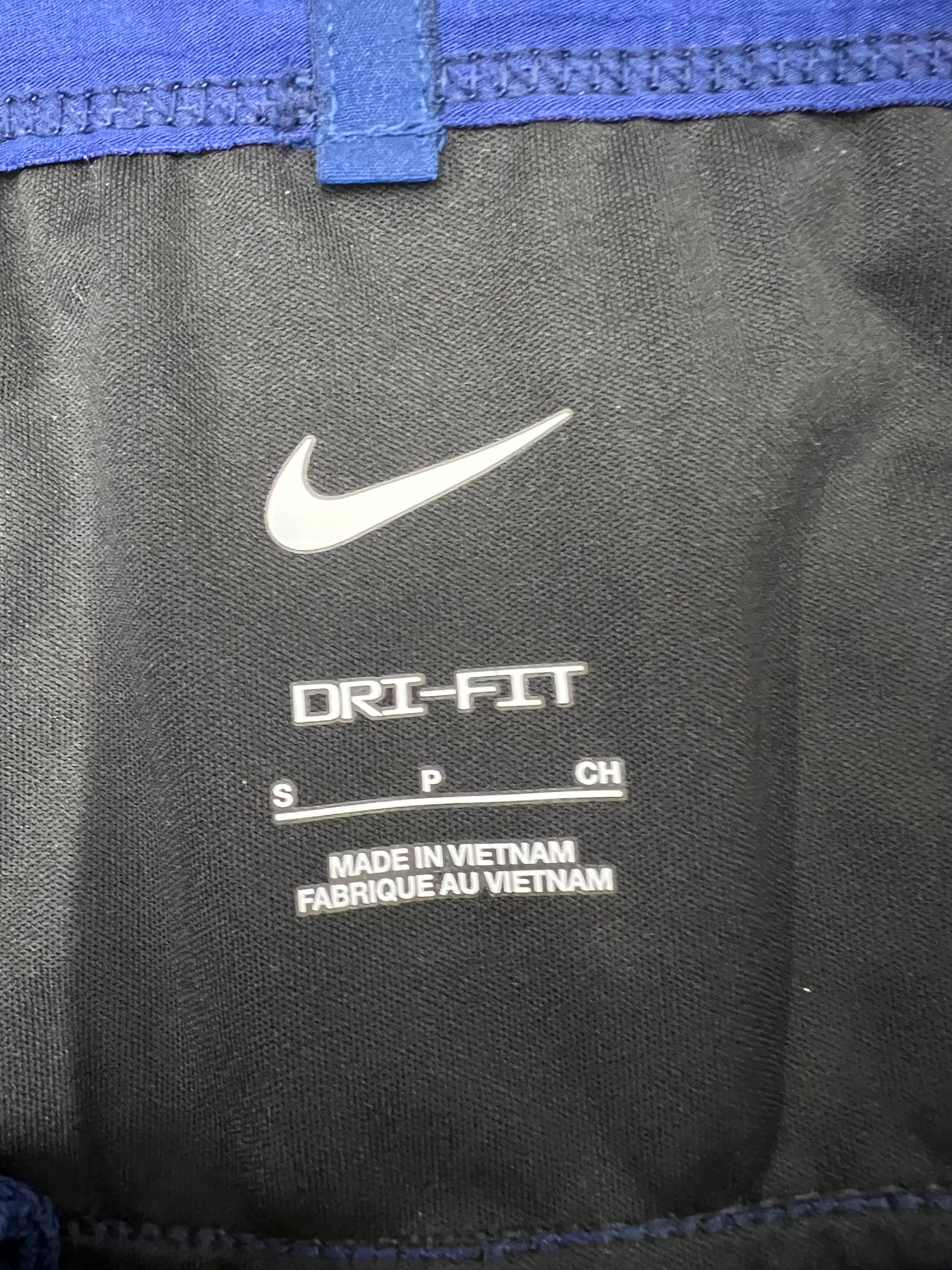 Interior label of Nike Women's navy blue Dri-FIT track pants showing size small and 'Made in Vietnam' text