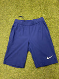 Nike women's long line Dri-FIT shorts in navy blue laid flat showing front side with Nike swoosh logo.