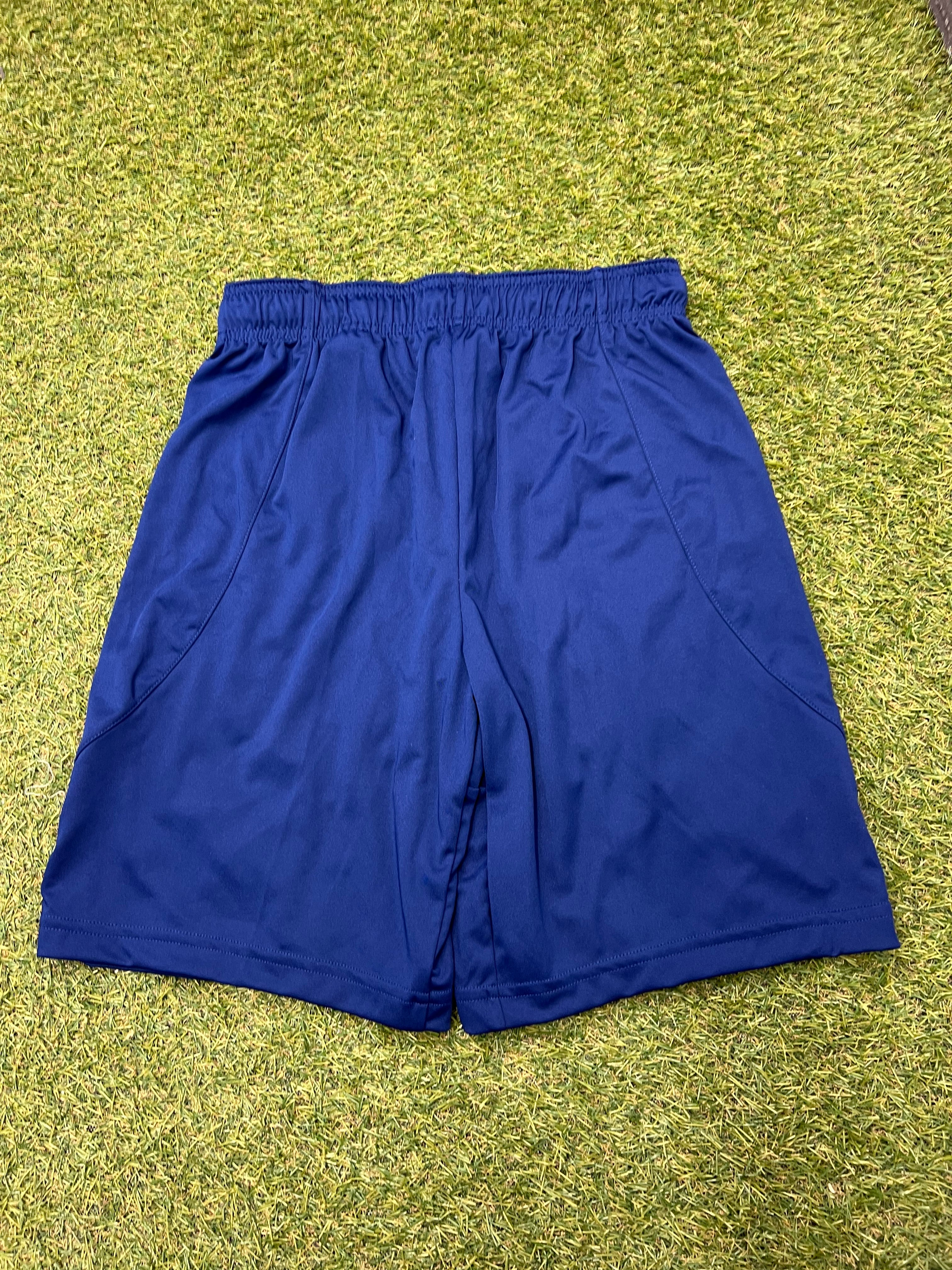 Back view of blue Nike sports shorts on grass highlighting the elastic waistband