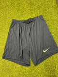 Front view of navy blue Nike men's athletic shorts on grass