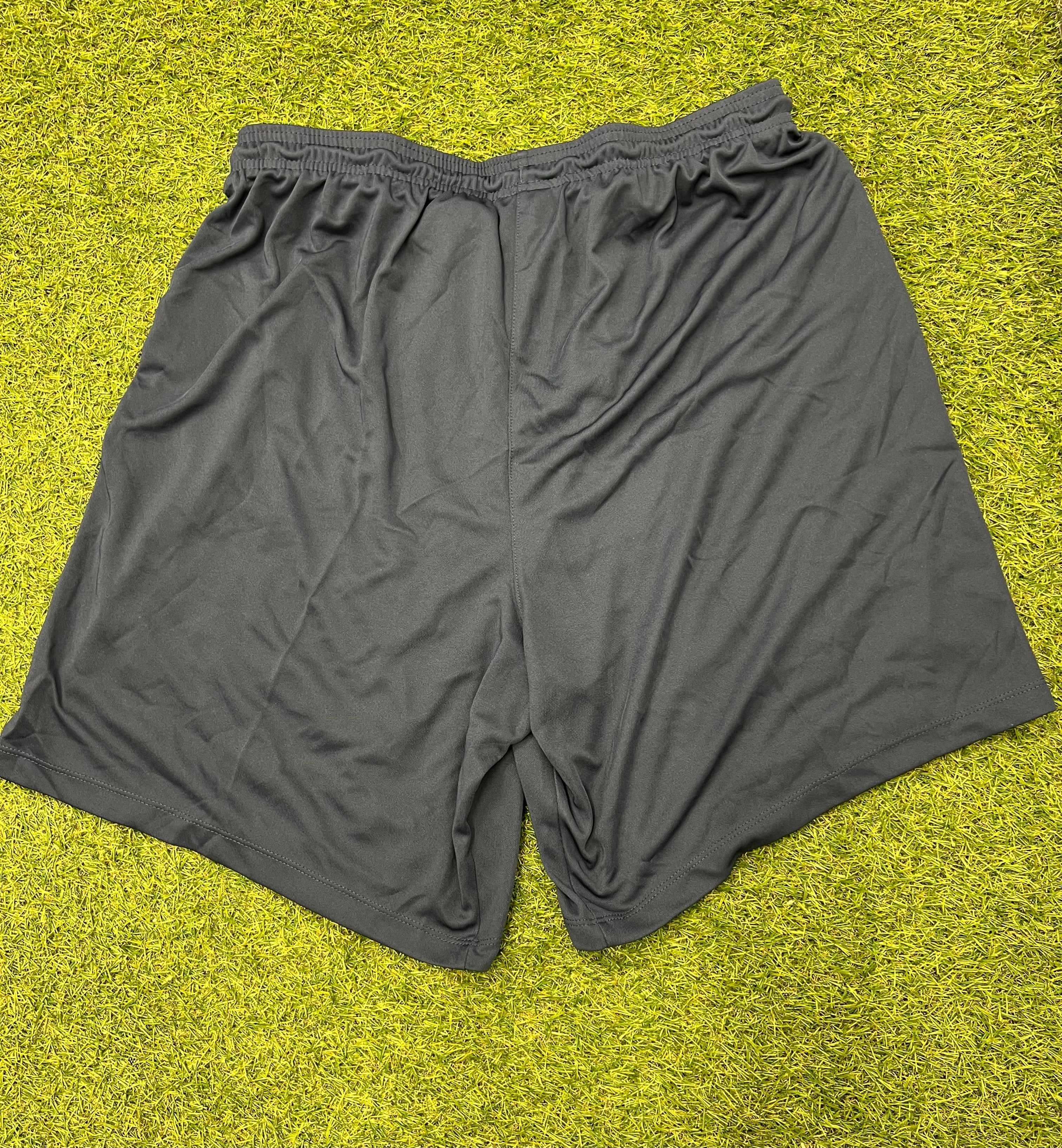 Back view of navy blue Nike men's athletic shorts laid flat on grass