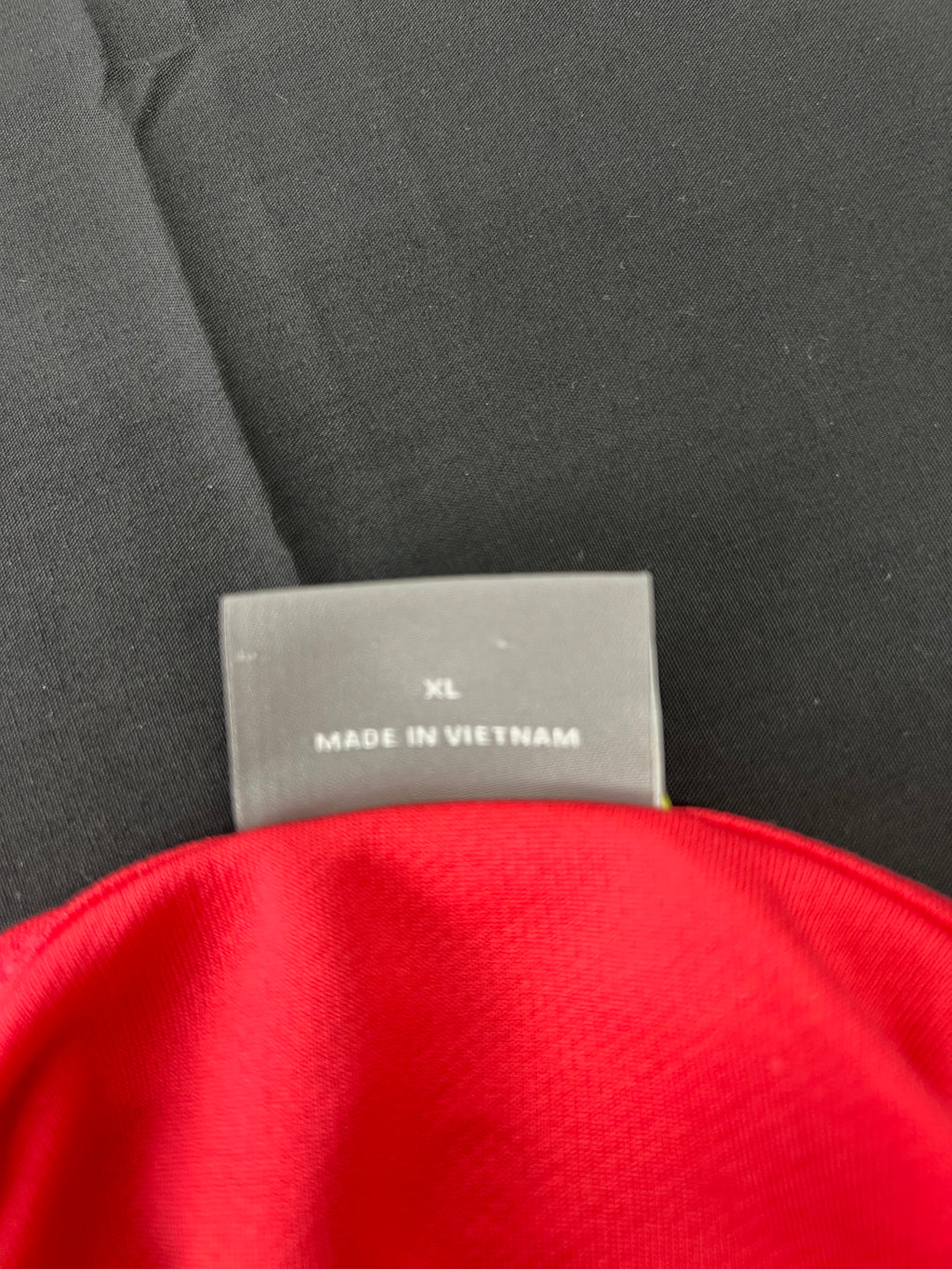 Close-up of size tag indicating XL and made in Vietnam inside the red Head women's sports t-shirt
