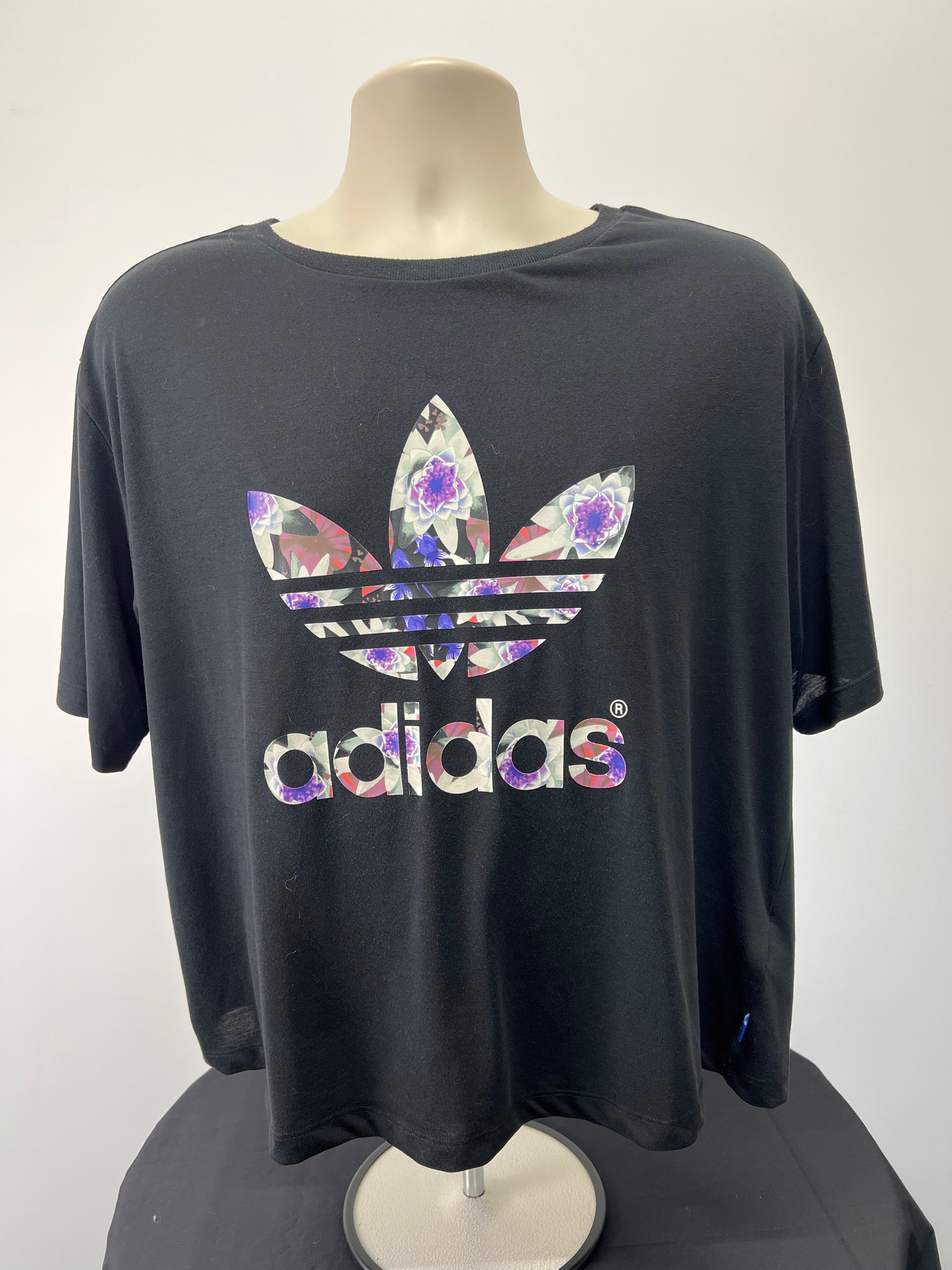 Front view of Adidas black women's t-shirt with floral Trefoil logo on chest