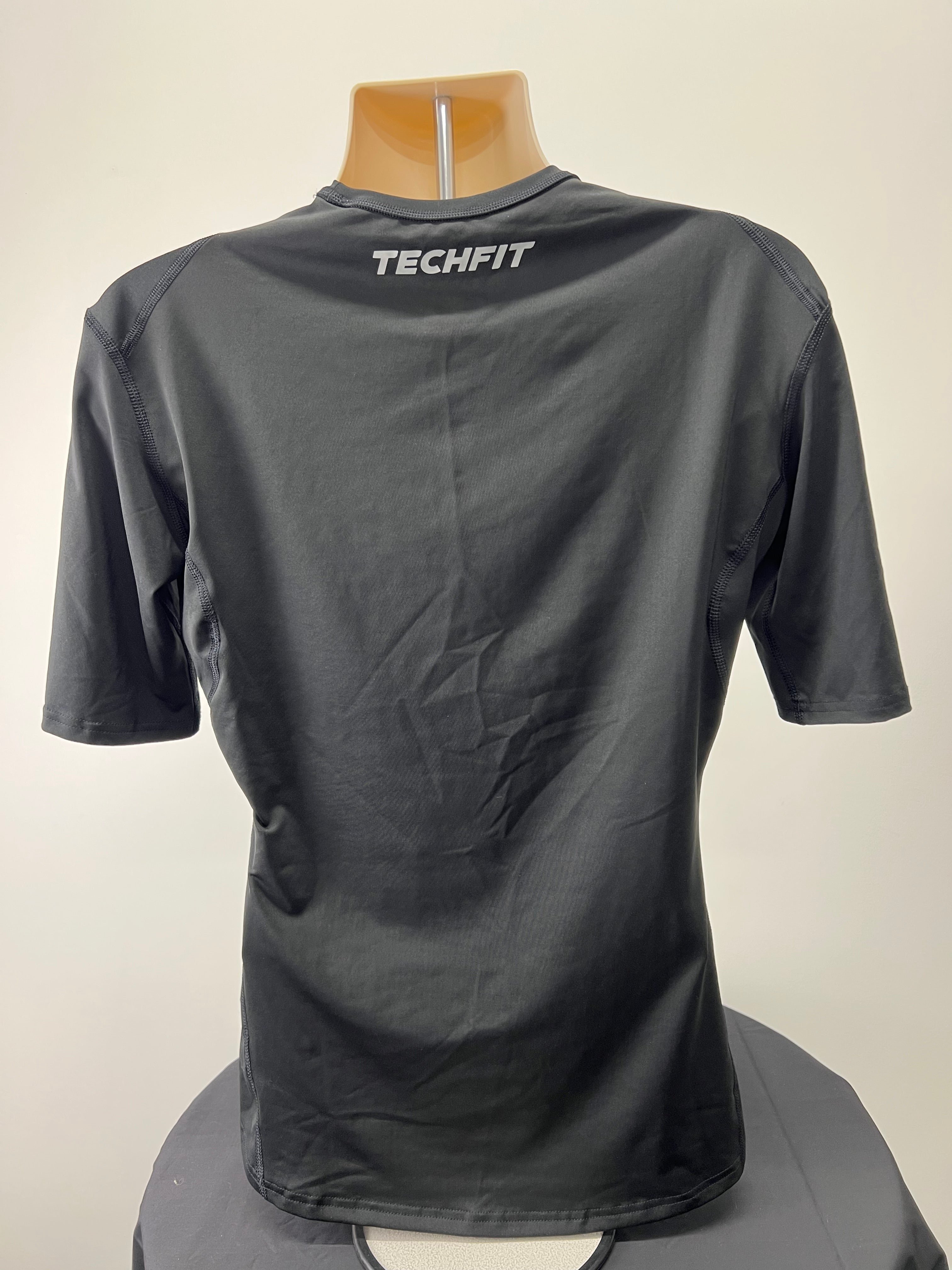 Back view of black Adidas Techfit compression short sleeve t-shirt with TECHFIT branding on upper back