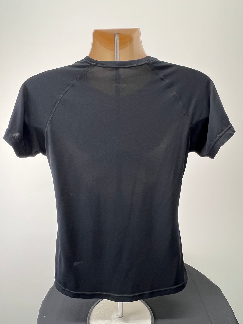 Back view of black Ronhill women's performance t-shirt on mannequin showing smooth fabric and stitching