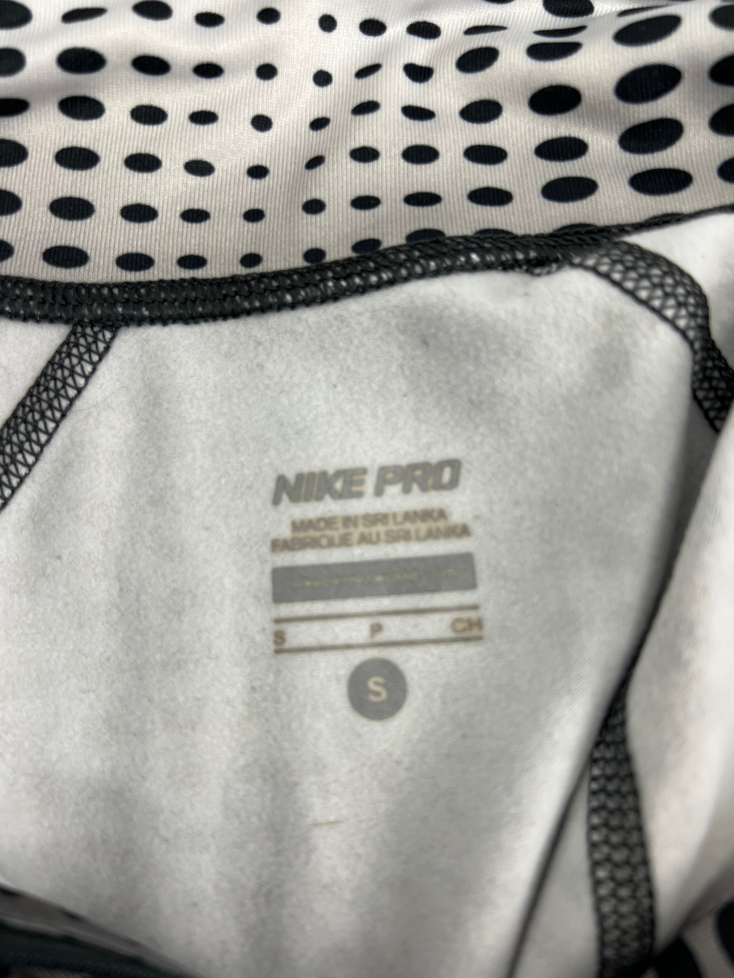 Close-up detail of Nike Pro size label printed inside the top showing size small and made in Sri Lanka