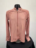Front view of peach coloured Sweaty Betty full zip active jacket with textured panels and thumb holes on sleeves