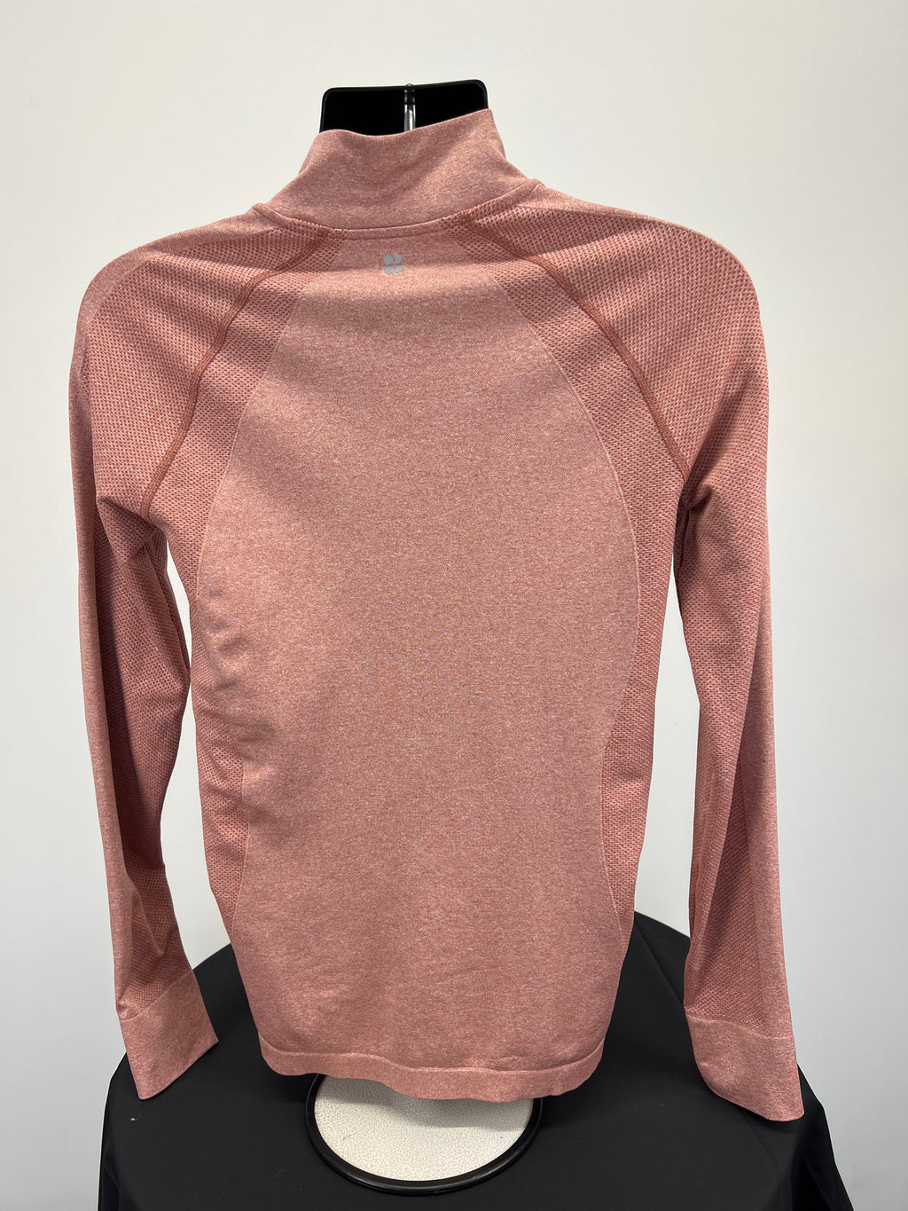 Back view of peach coloured Sweaty Betty full zip active jacket showing breathable knit texture and high collar