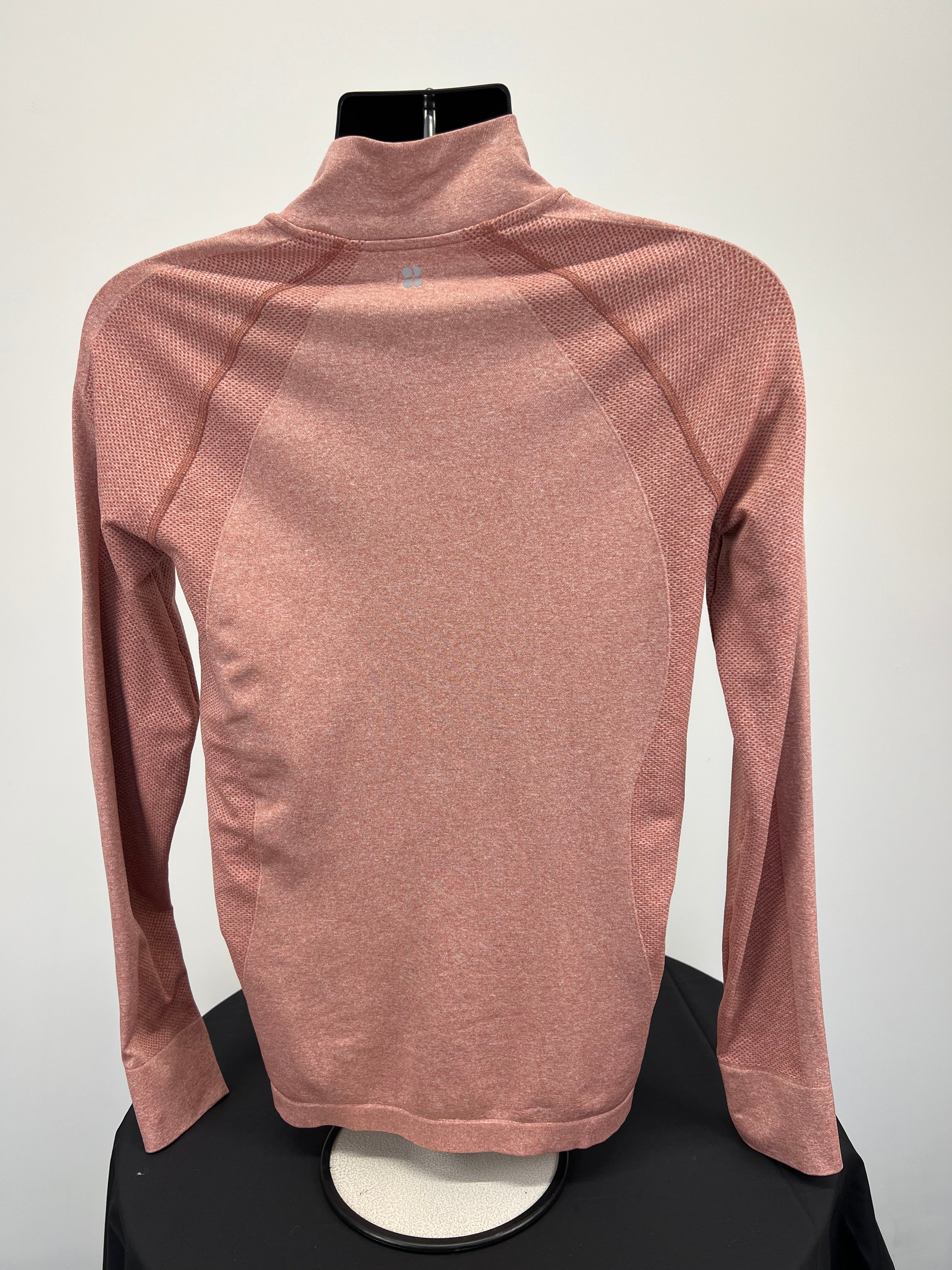 Back view of peach coloured Sweaty Betty full zip active jacket showing breathable knit texture and high collar