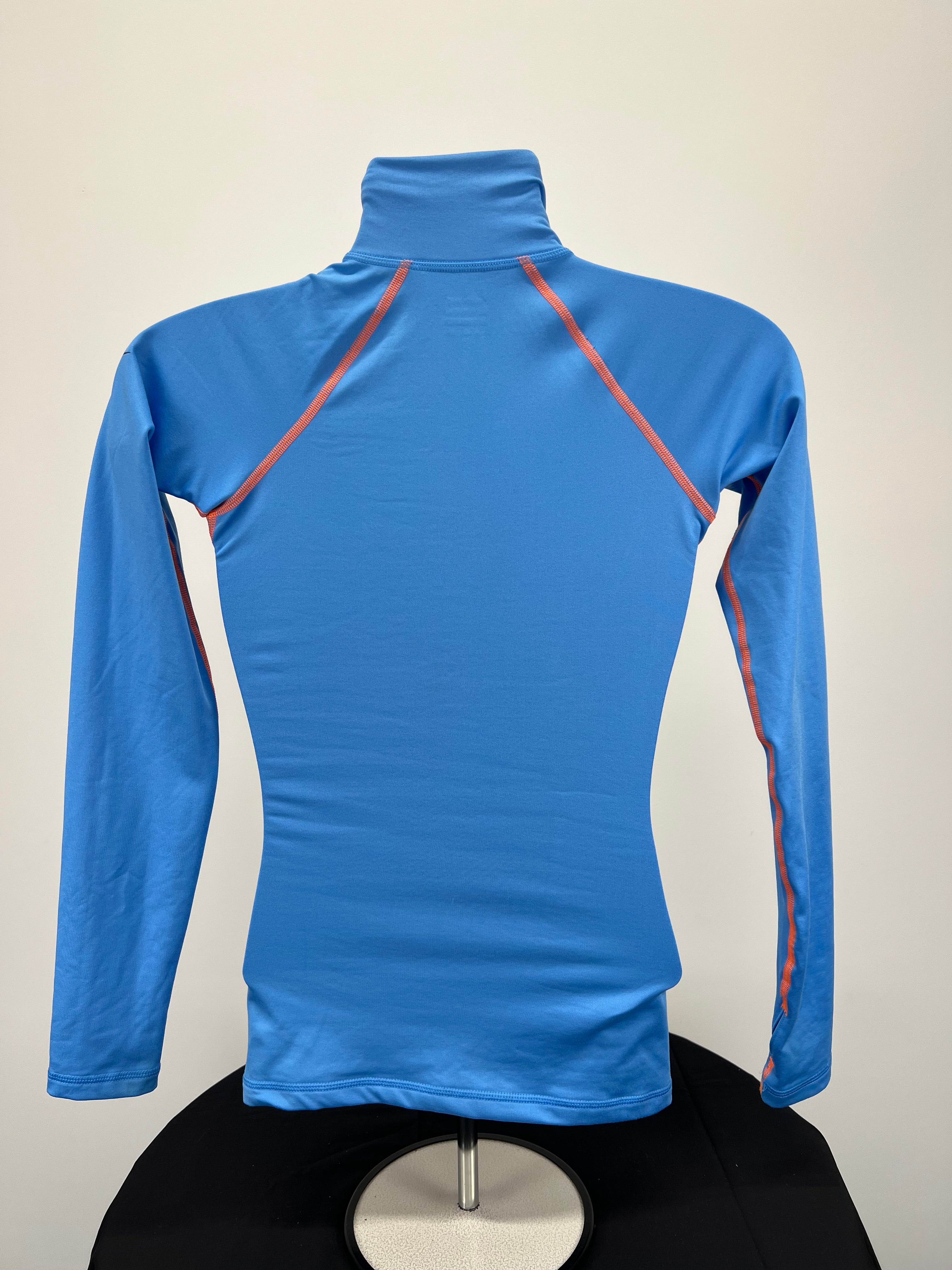Back view of blue Nike Pro long sleeve top showing plain fabric with orange seams and thumb holes on sleeves
