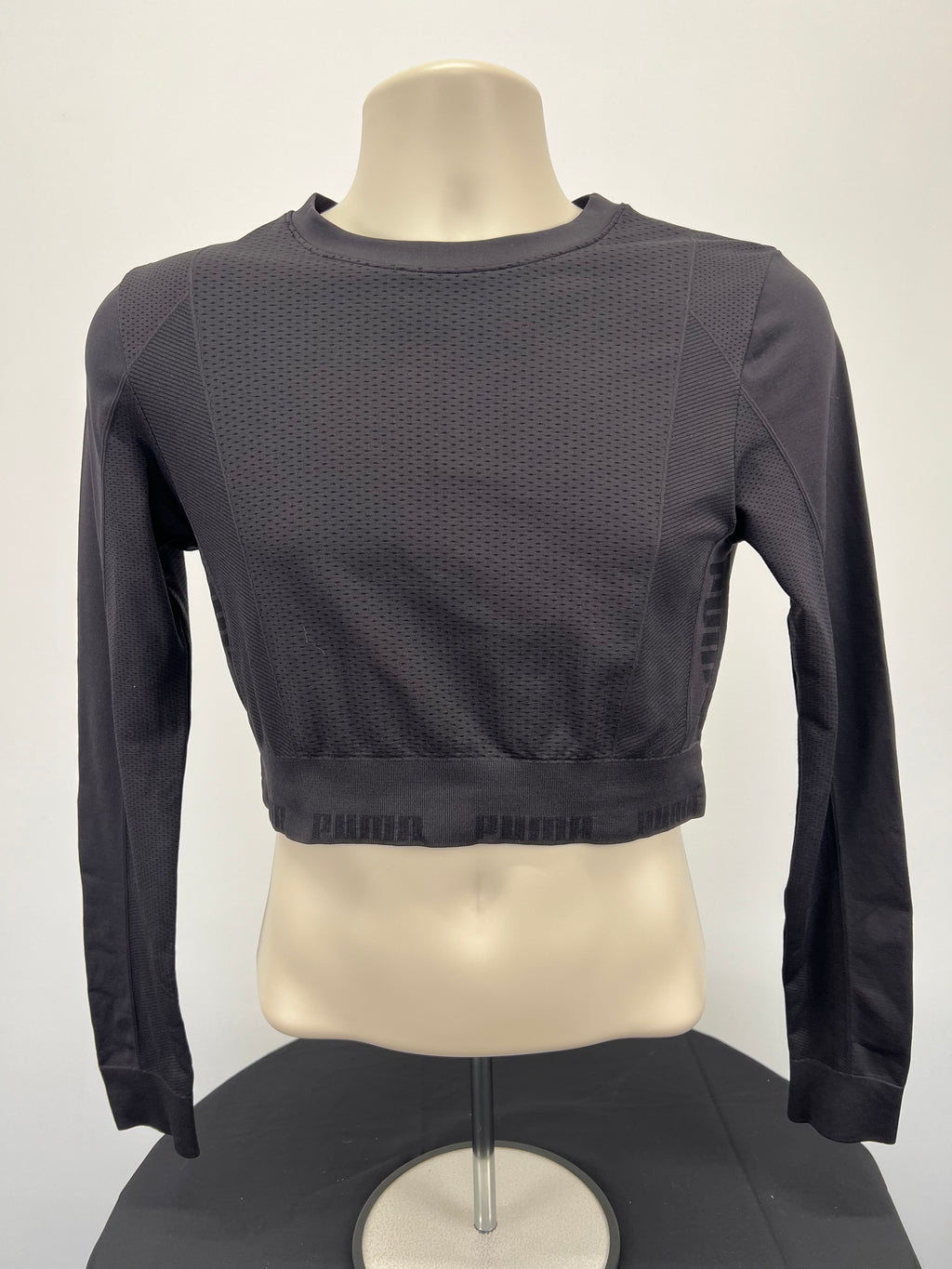 Front view of black Puma long sleeve crop top with breathable mesh fabric on mannequin