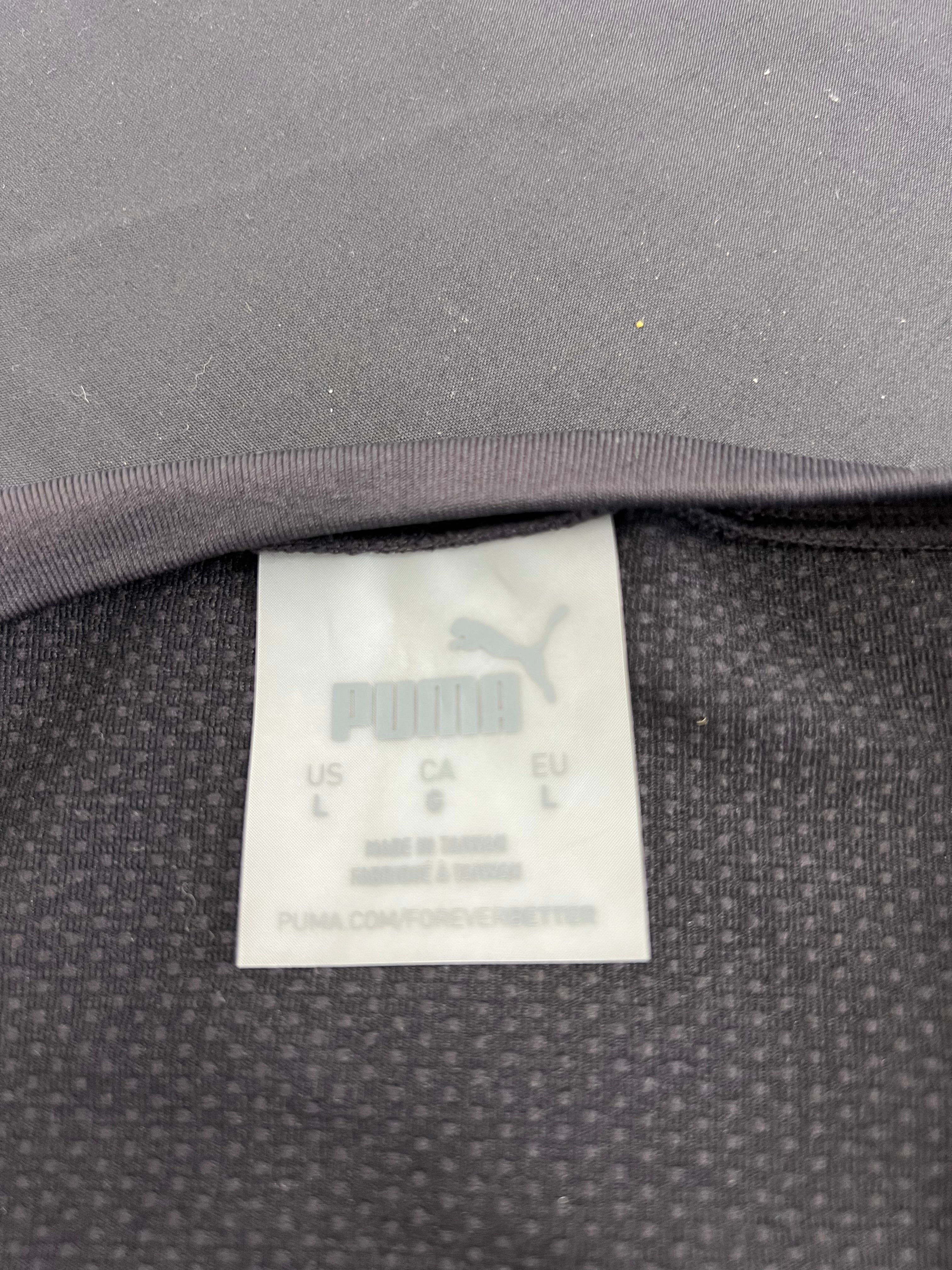 Close-up of Puma brand tag inside black mesh crop top showing size and care information