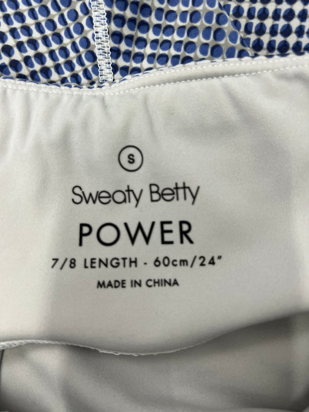Close-up of the inside label of Sweaty Betty Power leggings indicating size small, 7/8 length, made in China