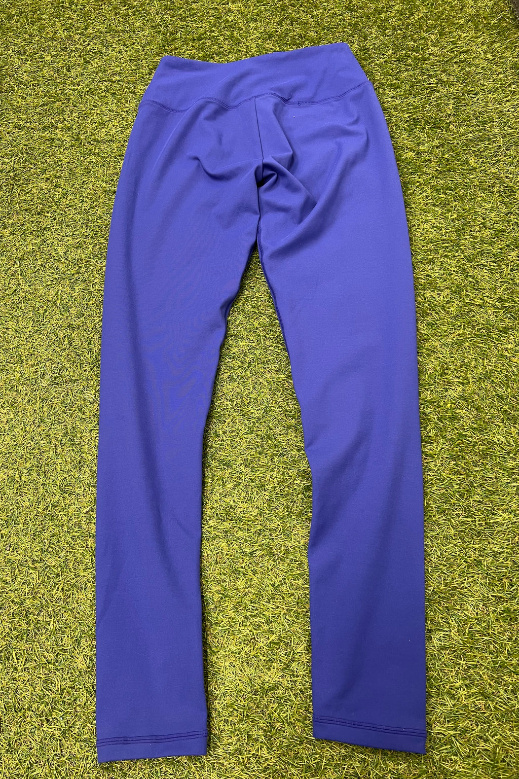 Back view of blue Gymshark moisture management leggings showing seam details on grass