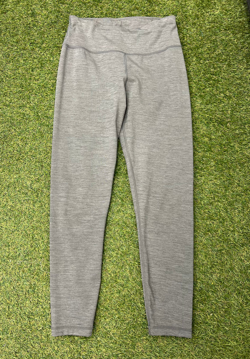 Front view of grey Sweaty Betty leggings laid flat on grass surface