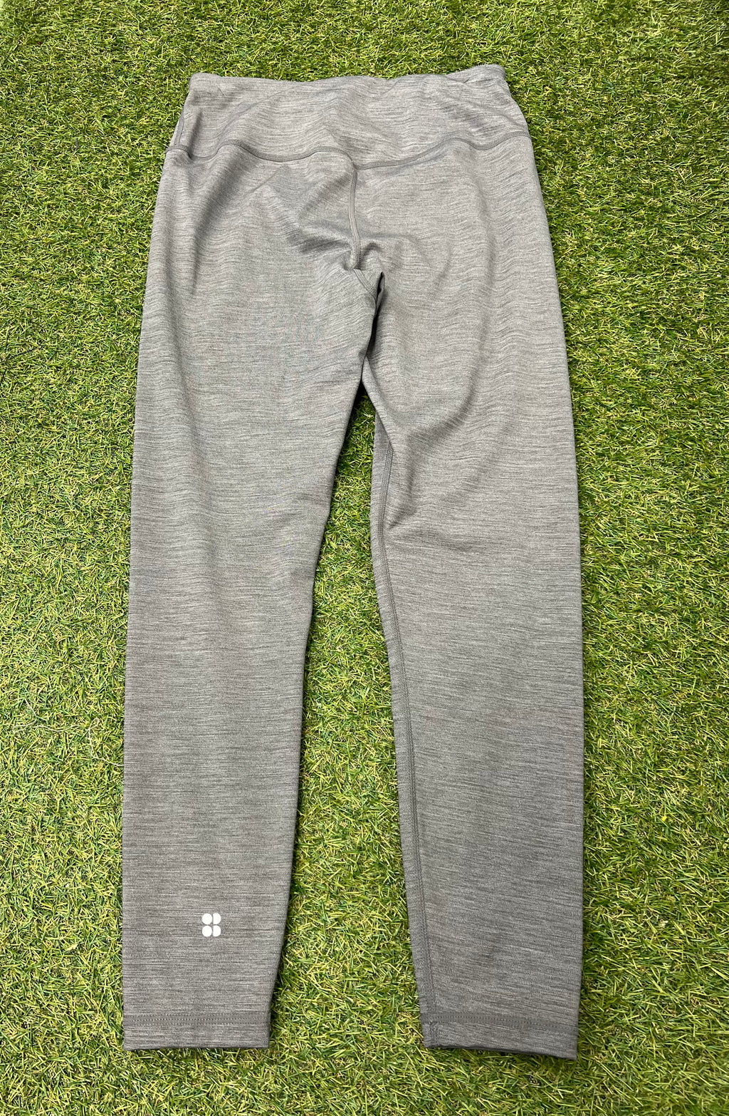 Back view of grey Sweaty Betty leggings showing high waistband and reflective logo