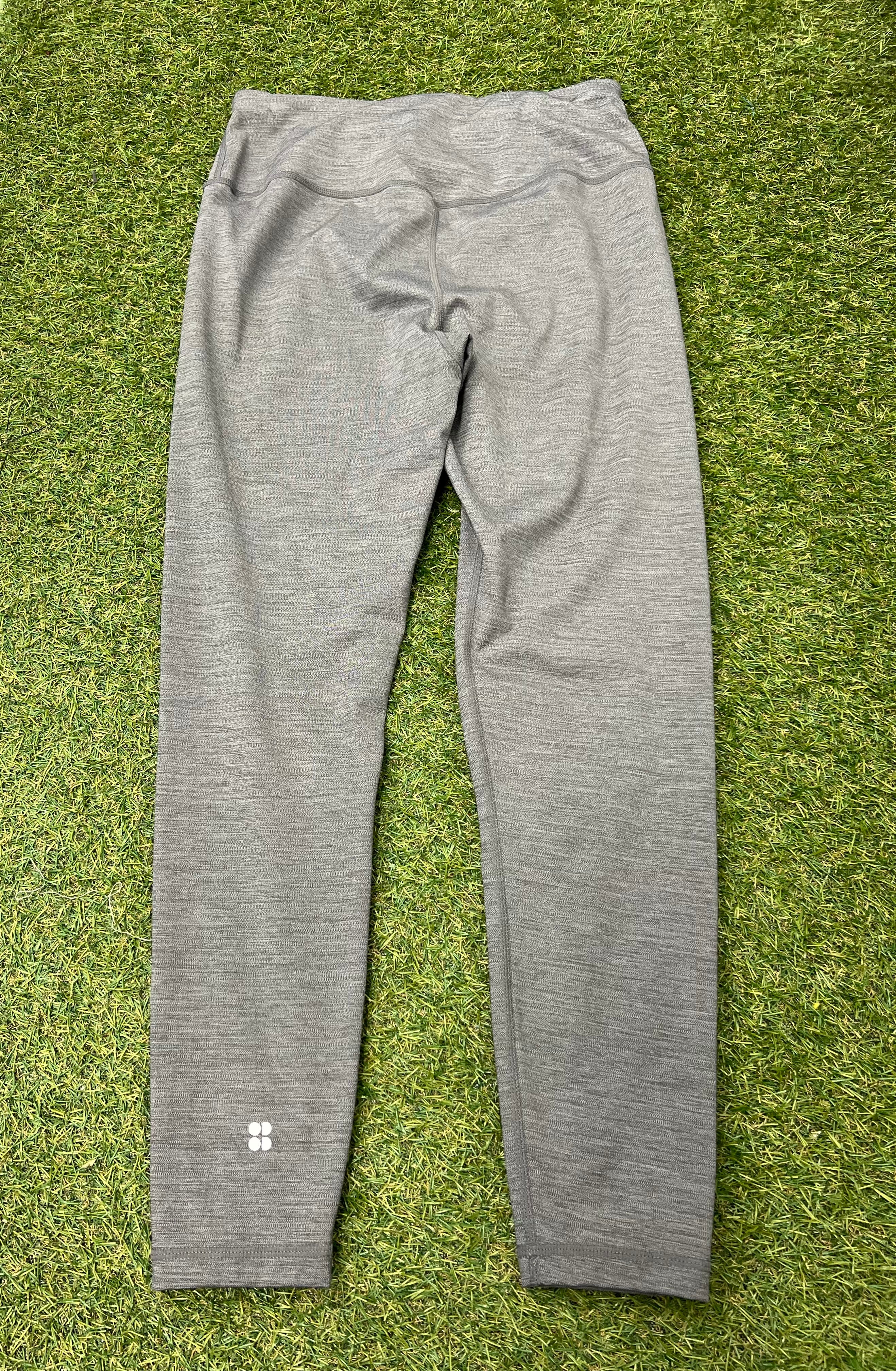 Back view of grey Sweaty Betty leggings showing high waistband and reflective logo