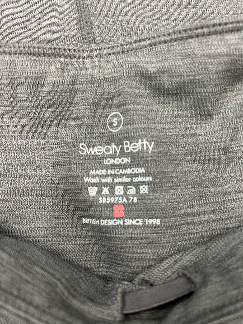 Close-up detail of Sweaty Betty label and care instructions inside the grey leggings